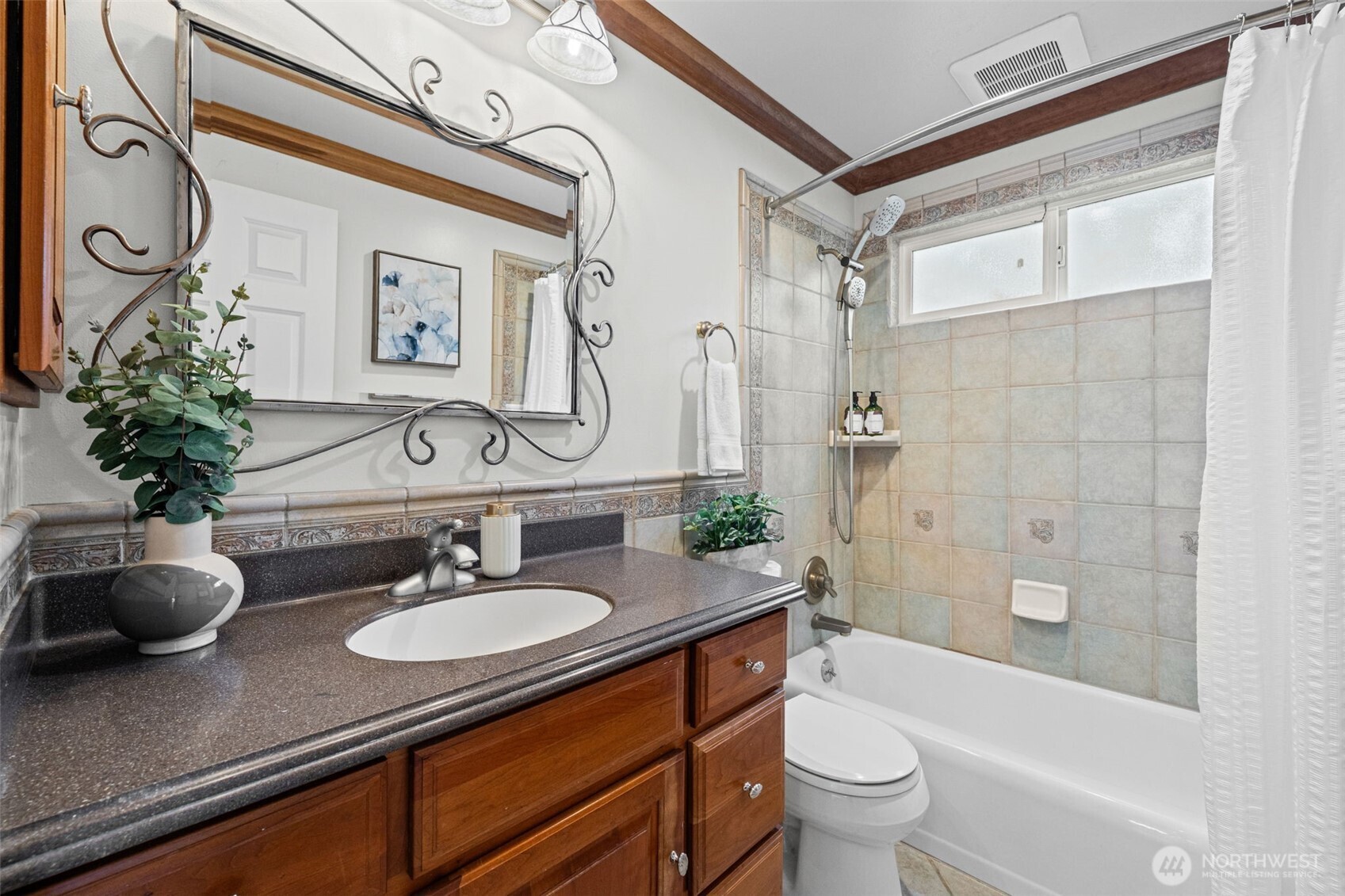 Full bathroom with tile tub/shower surround, quartz vanity, and ample counter space. Functional layout with clean finishes supports everyday living with ease.