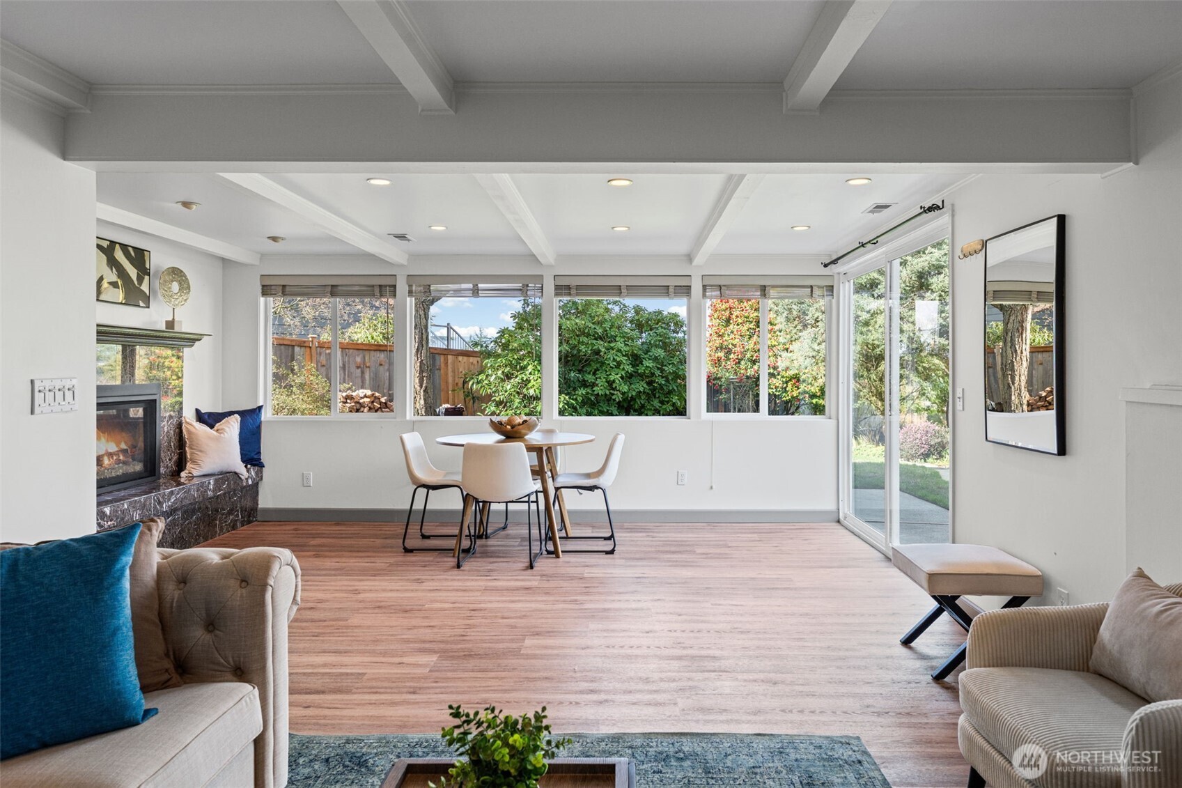 Open layout connects seamlessly to the patio through sliding glass doors, offering easy indoor-outdoor living. Large windows frame the private backyard while keeping the space bright and connected.