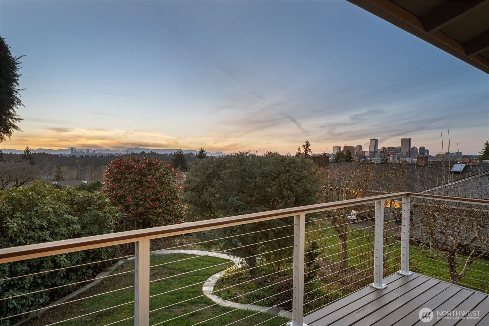Elevated deck retreat offering front-row seats to vibrant sunsets—perfect for evening relaxation while taking in the Bellevue skyline to the right, Seattle to the left, and the Olympic Mountain range in the background.