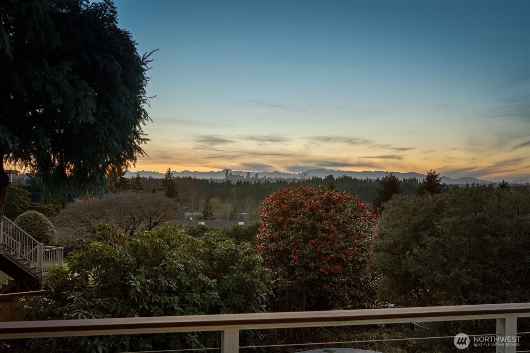 Serene backyard setting at dusk with lush greenery and glowing skies, creating a peaceful backdrop with distant city and mountain silhouettes.