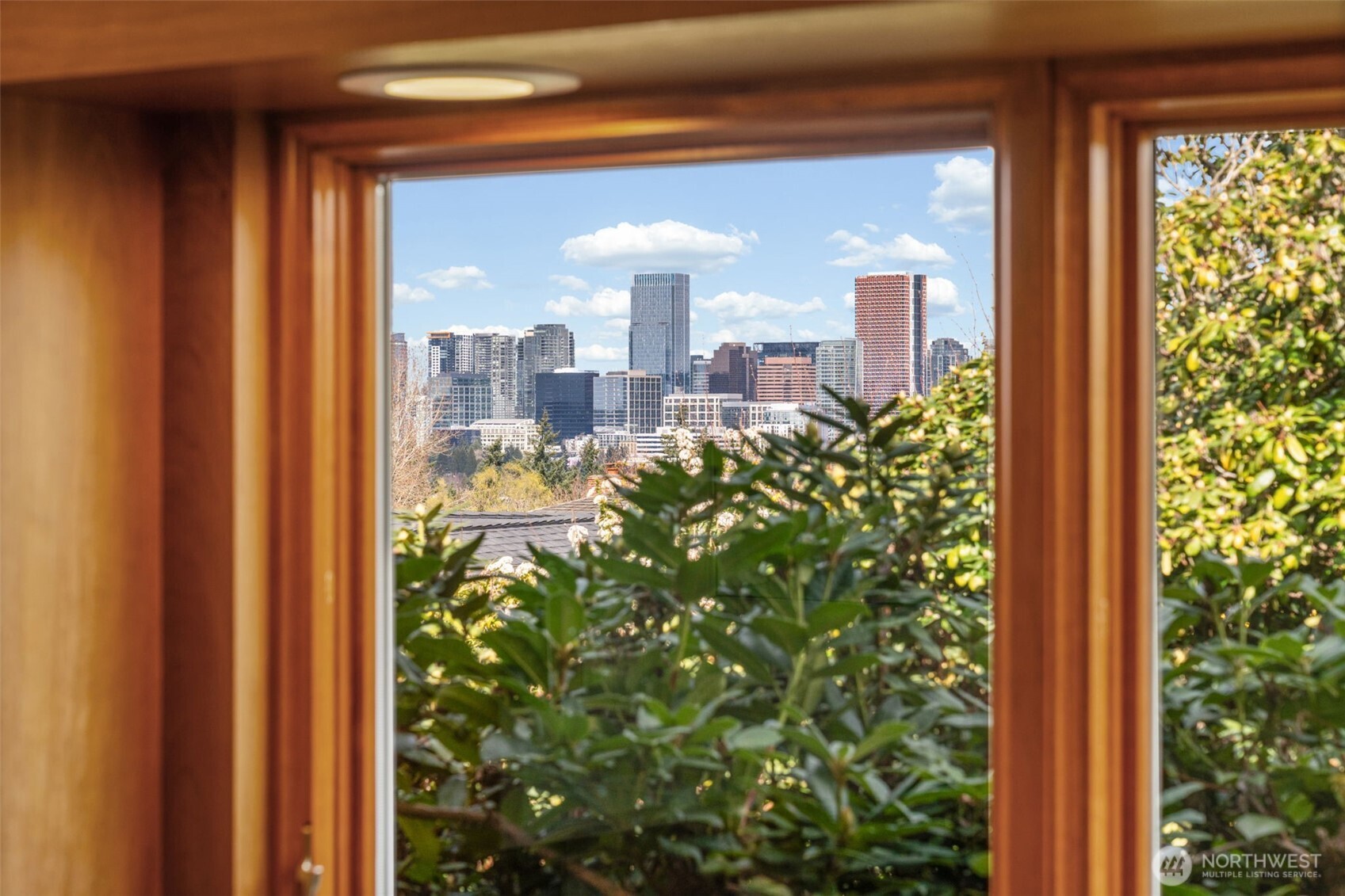 Framed by the kitchen window, enjoy serene greenery in the foreground with stunning Bellevue skyline views beyond—bringing natural beauty and cityscape together in one picturesque outlook.
