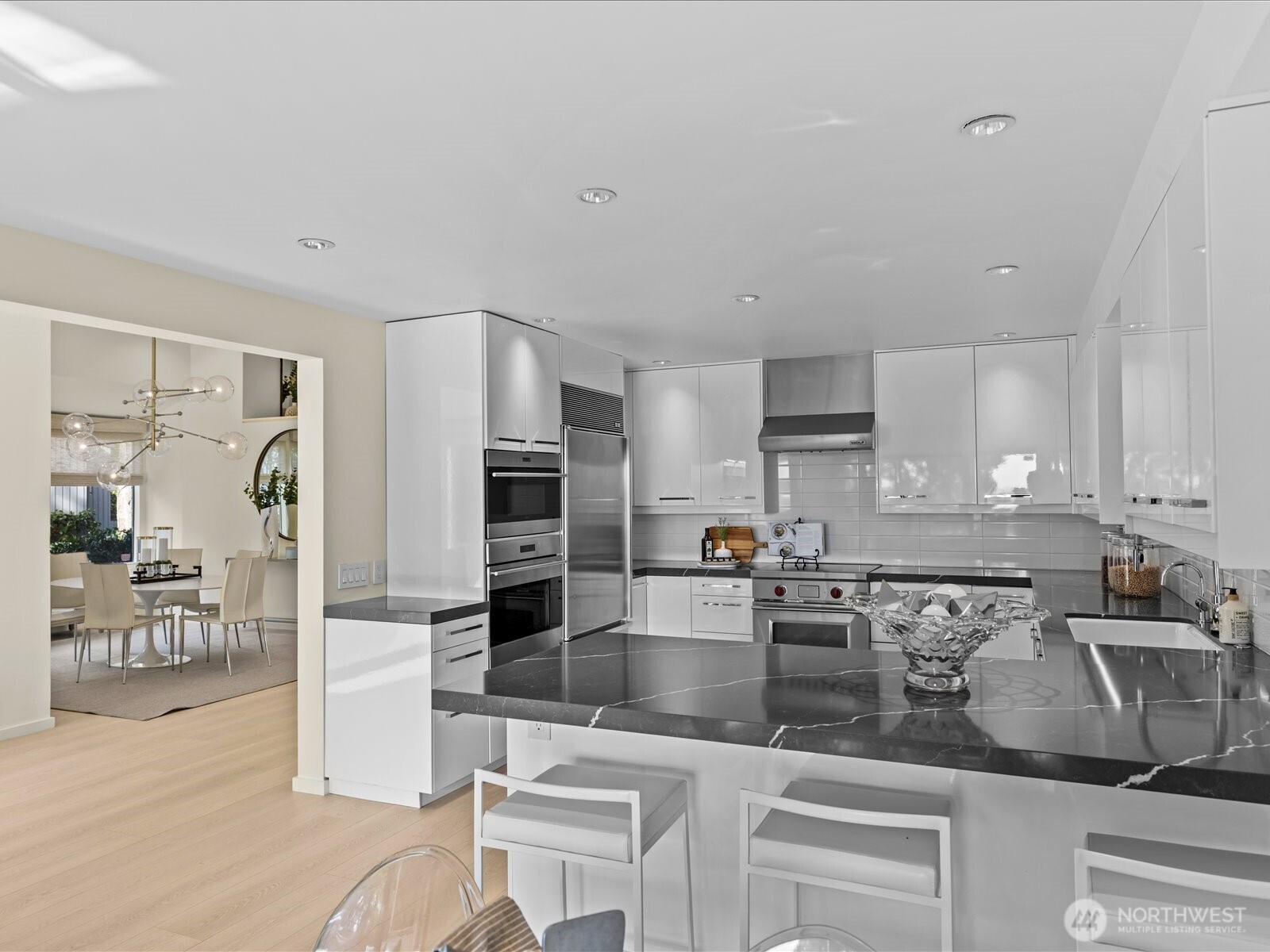 Premium culinary suite featuring Slab Onyx counters, Sub-Zero refrigeration, and a full Miele/Wolf appliance package, insta hot and soft close drawers. Peninsula easily seats three.