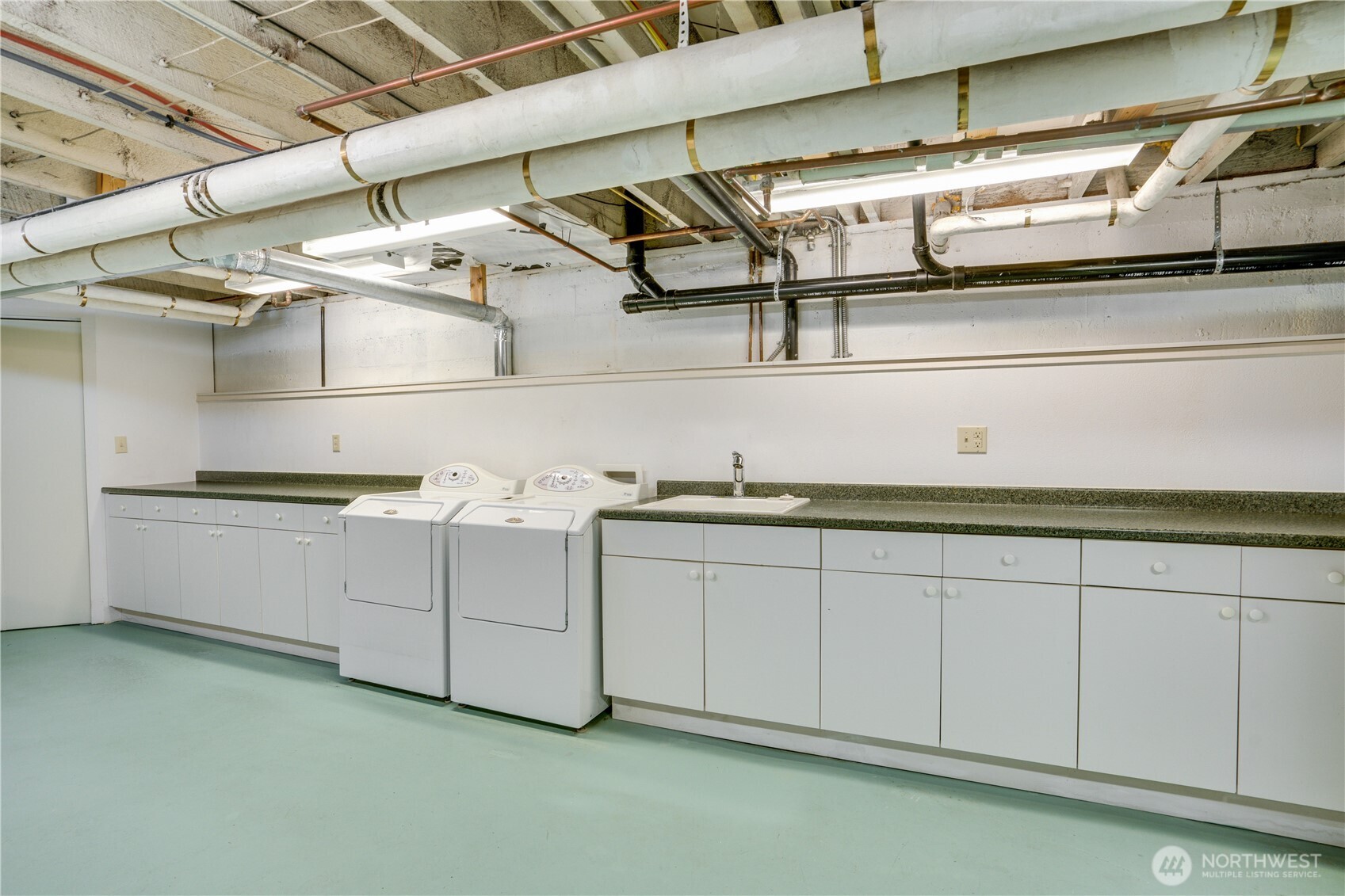 Utility room with built-in cabinetry and laundry.