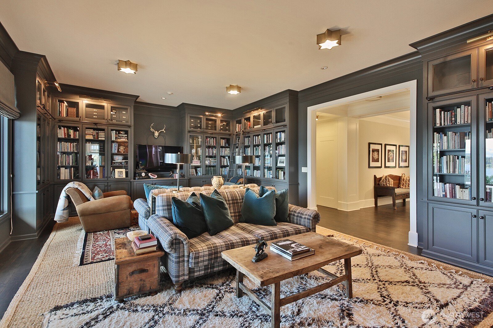 Library with floor-to-ceiling built-in shelves, fireplace, and water views.