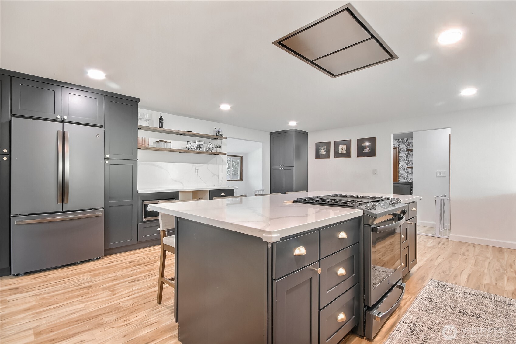 Modern trendy kitchen with stainless steel appliances and desk or wine frig area.