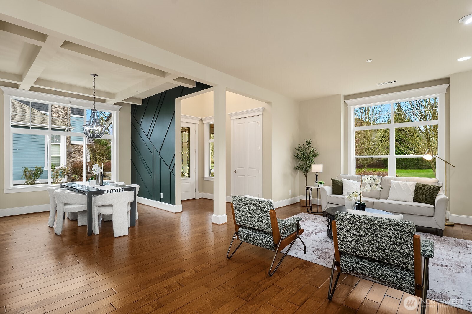 A stylish barn door adds a charming architectural detail to this versatile flex space, which flows openly between the living areas and offers rich hardwood floors, abundant natural light, and a warm, inviting atmosphere.