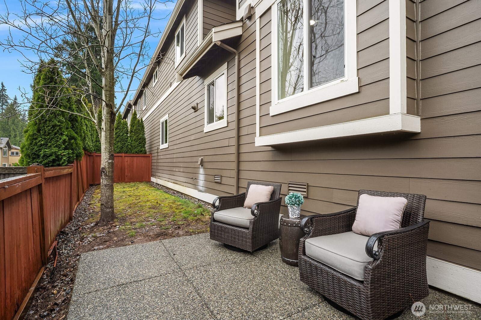 The private patio offers a charming outdoor retreat with comfortable seating and a fully fenced yard, framed by the home's classic exterior — a perfect spot for relaxing or enjoying the fresh Pacific Northwest air.