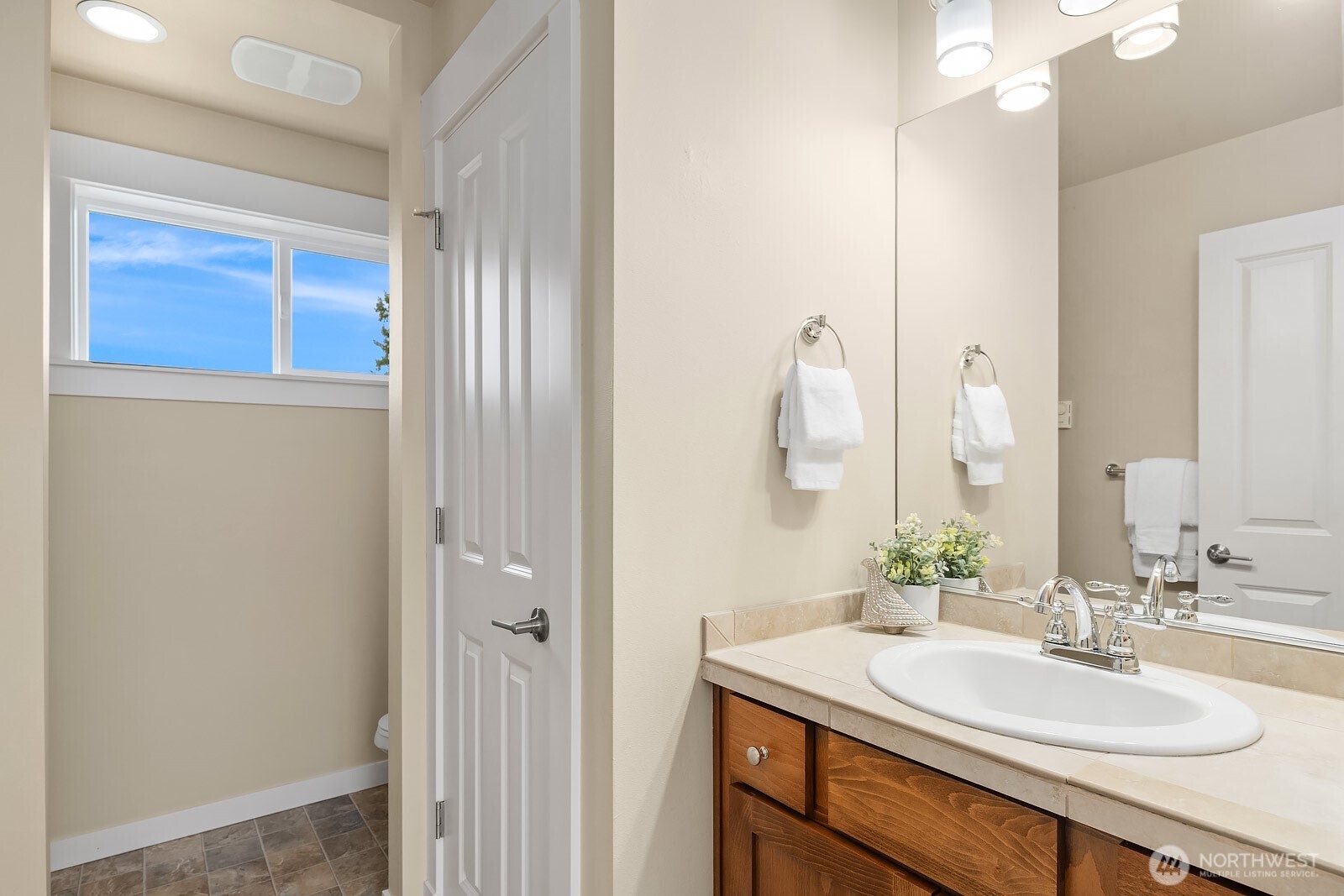 The ADU's 3/4 bath features a clean and functional design with a warm wood vanity and bright lighting — a well-appointed space that completes this fully self-contained and permitted above-garage unit.