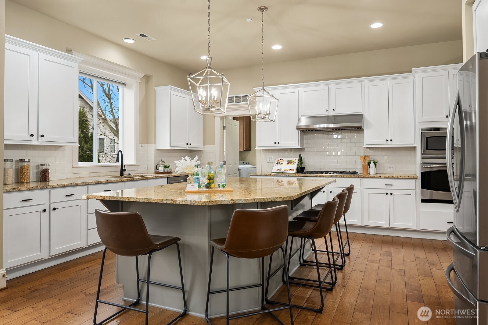 Another angle of the kitchen showcases the generous wraparound island, elegant pendant lighting, and premium appliances — a beautifully designed space that flows effortlessly for both everyday cooking and entertaining.