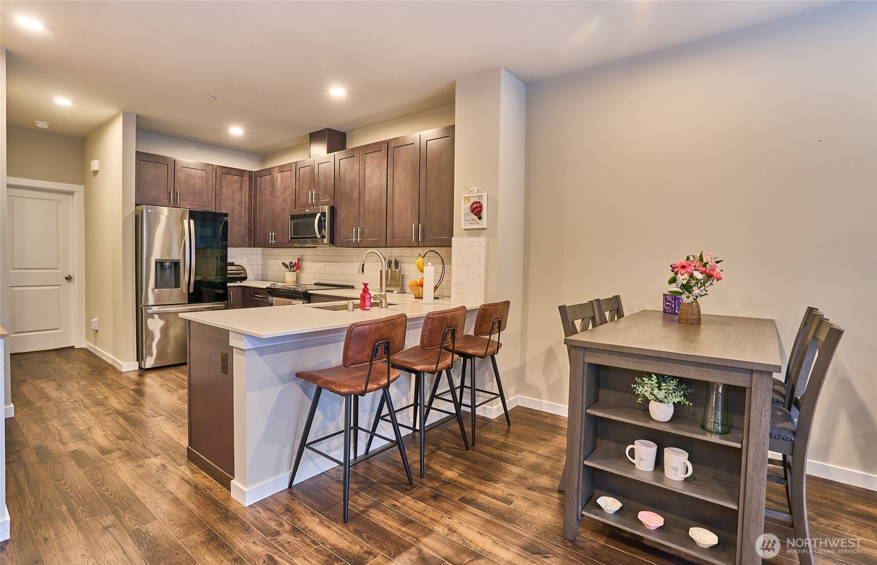 Dining area with large kitchen, stainless steel appliances and quartz counter tops.