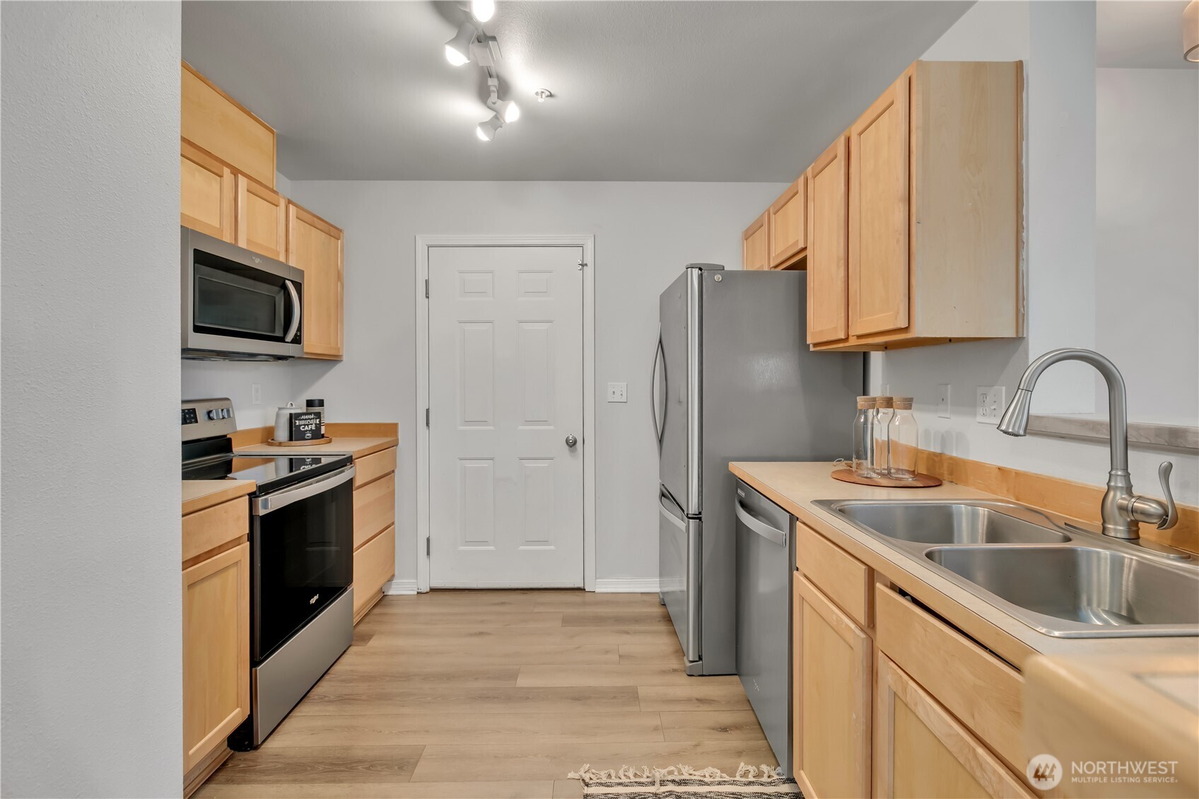 Kitchen features stainless steel appliance and opens to the living and dining areas.