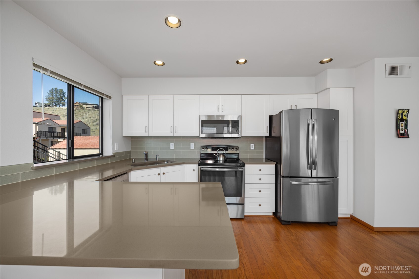 Kitchen with gorgeous quartz counters, shaker cabinets and stainless steel appliances.