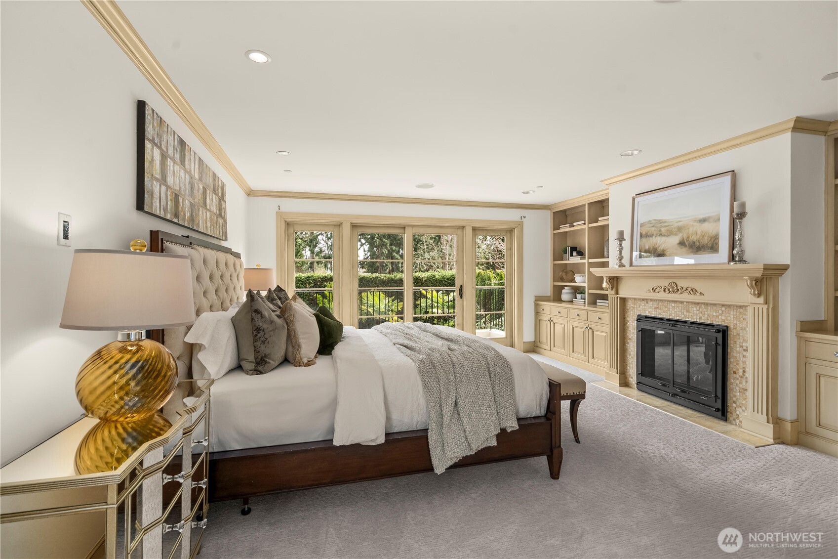 Elegant primary suite featuring a fireplace, custom built-ins, and French doors to a private balcony retreat