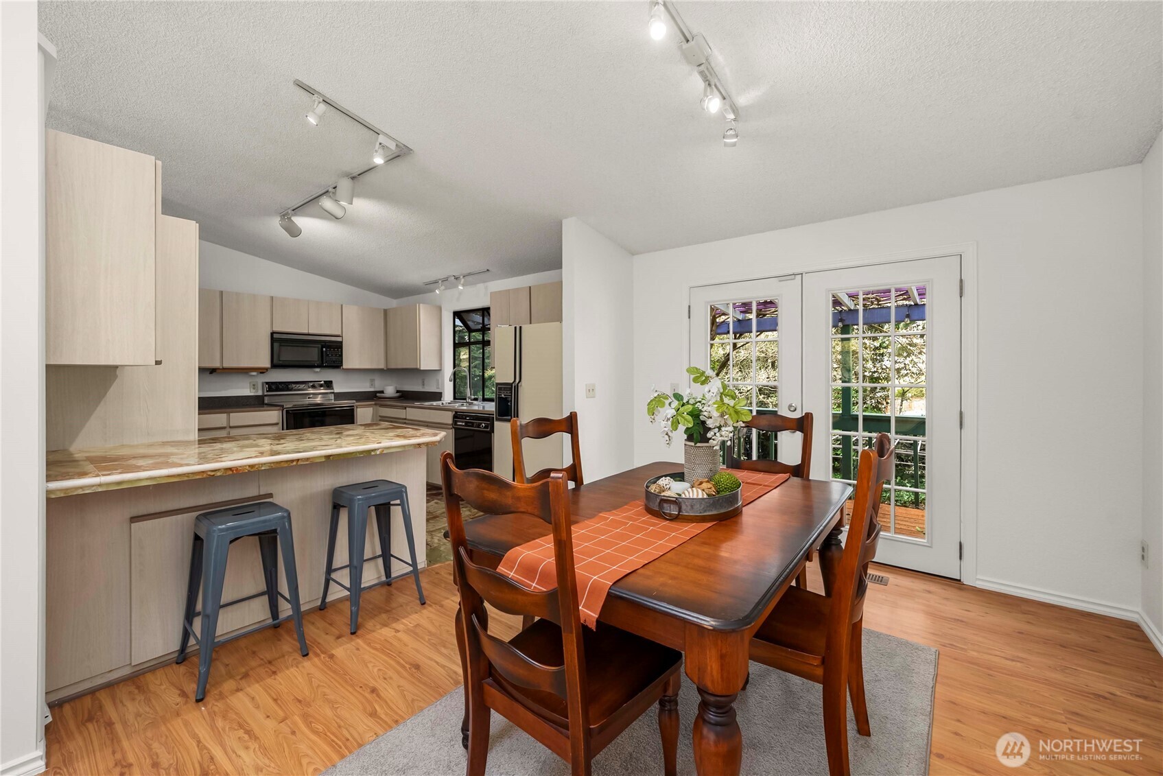 A view into the kitchen with breakfast bar and tile counters
