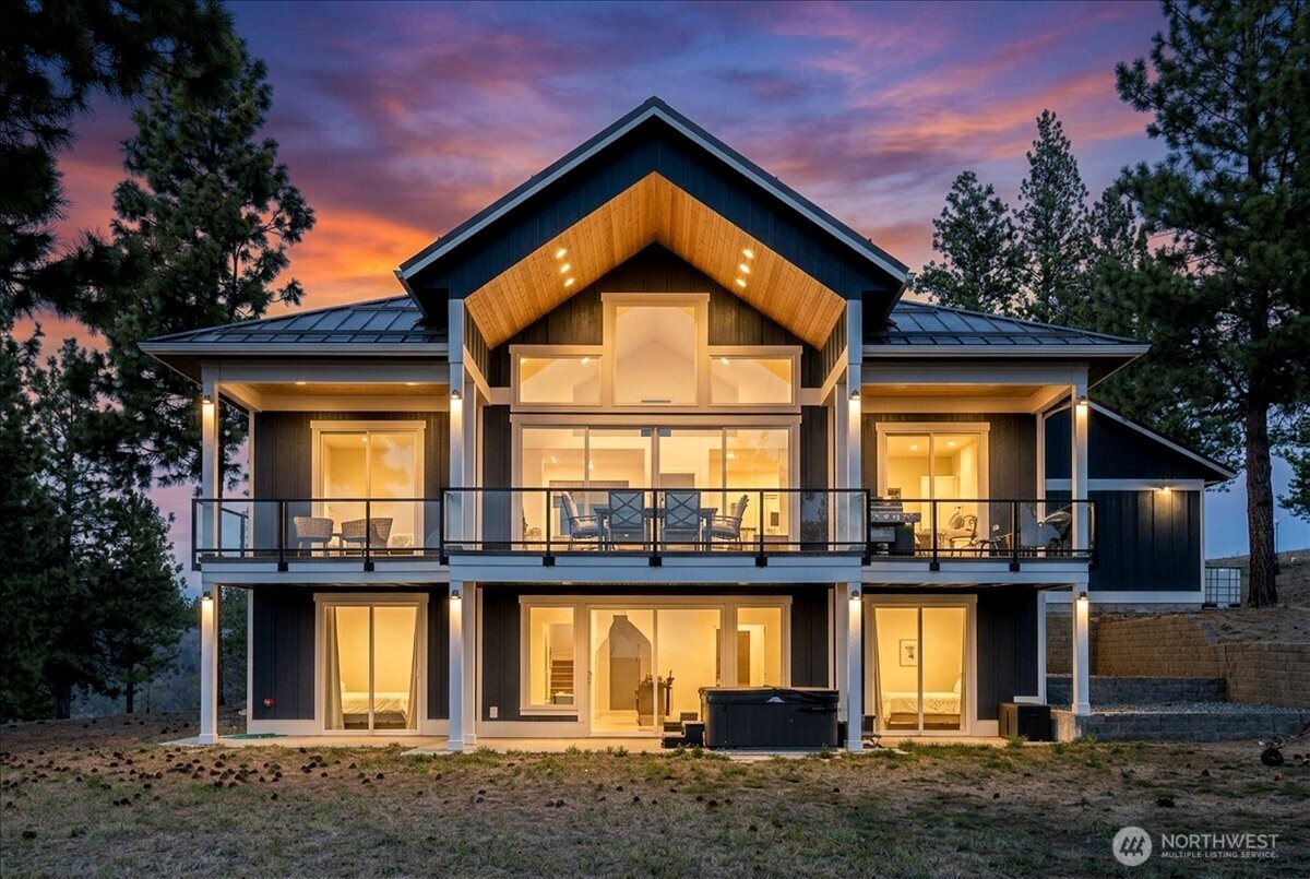 Twilight View of back of home wtih all windows, decks and architecture design