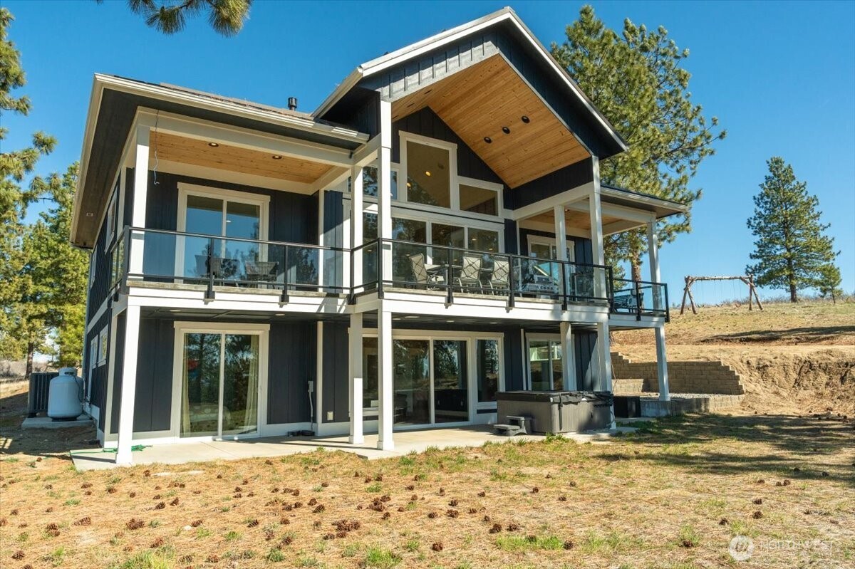 View of back of home wtih all windows, decks and architecture design