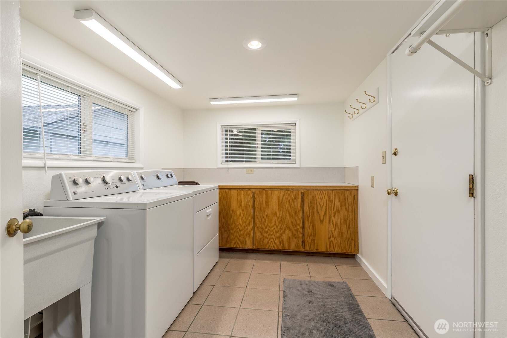 Laundry/mudroom includes cabinetry, folding counter and utility sink
