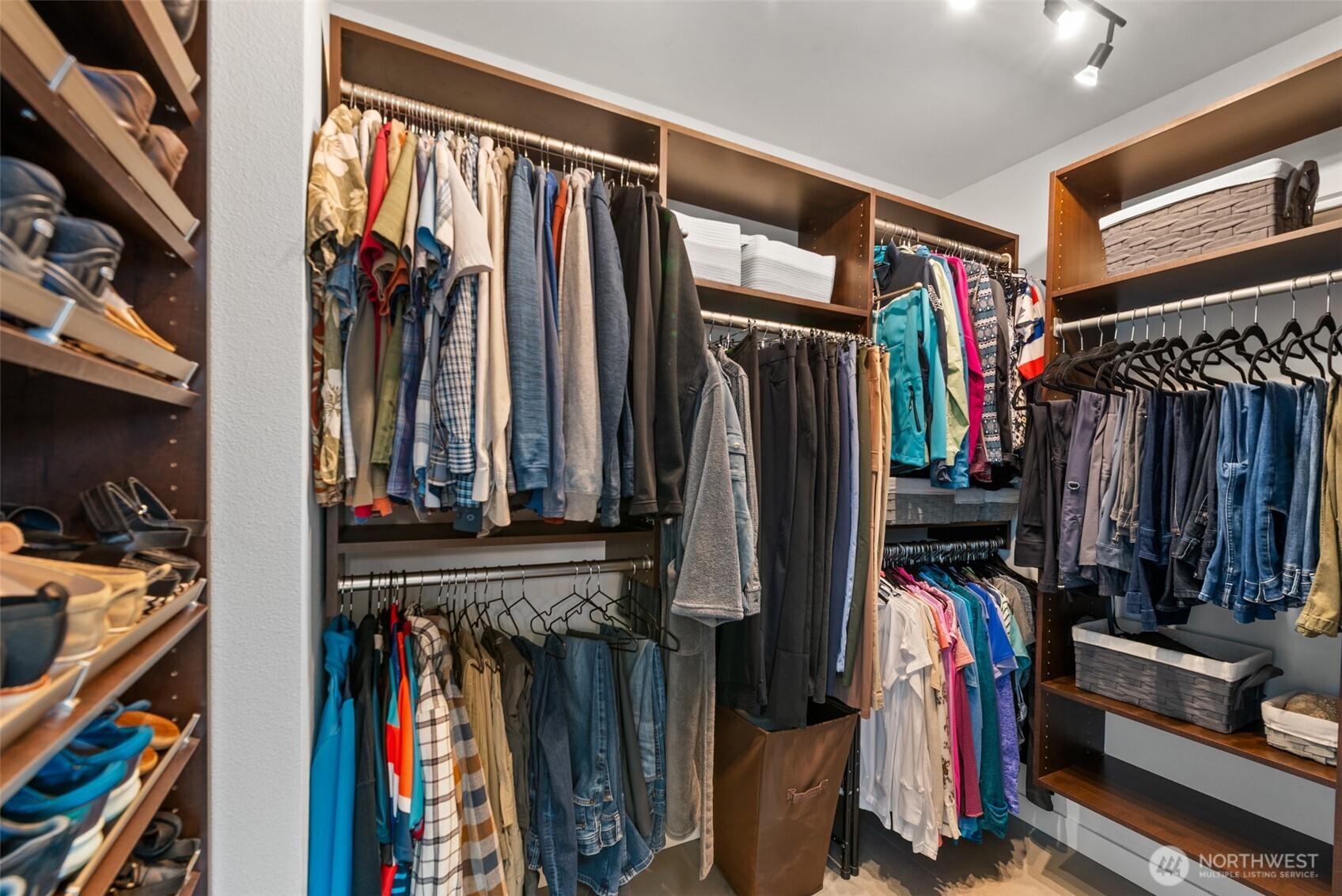 Generous primary walk-in closet featuring heated floors and a custom closet system for efficient storage and organization.