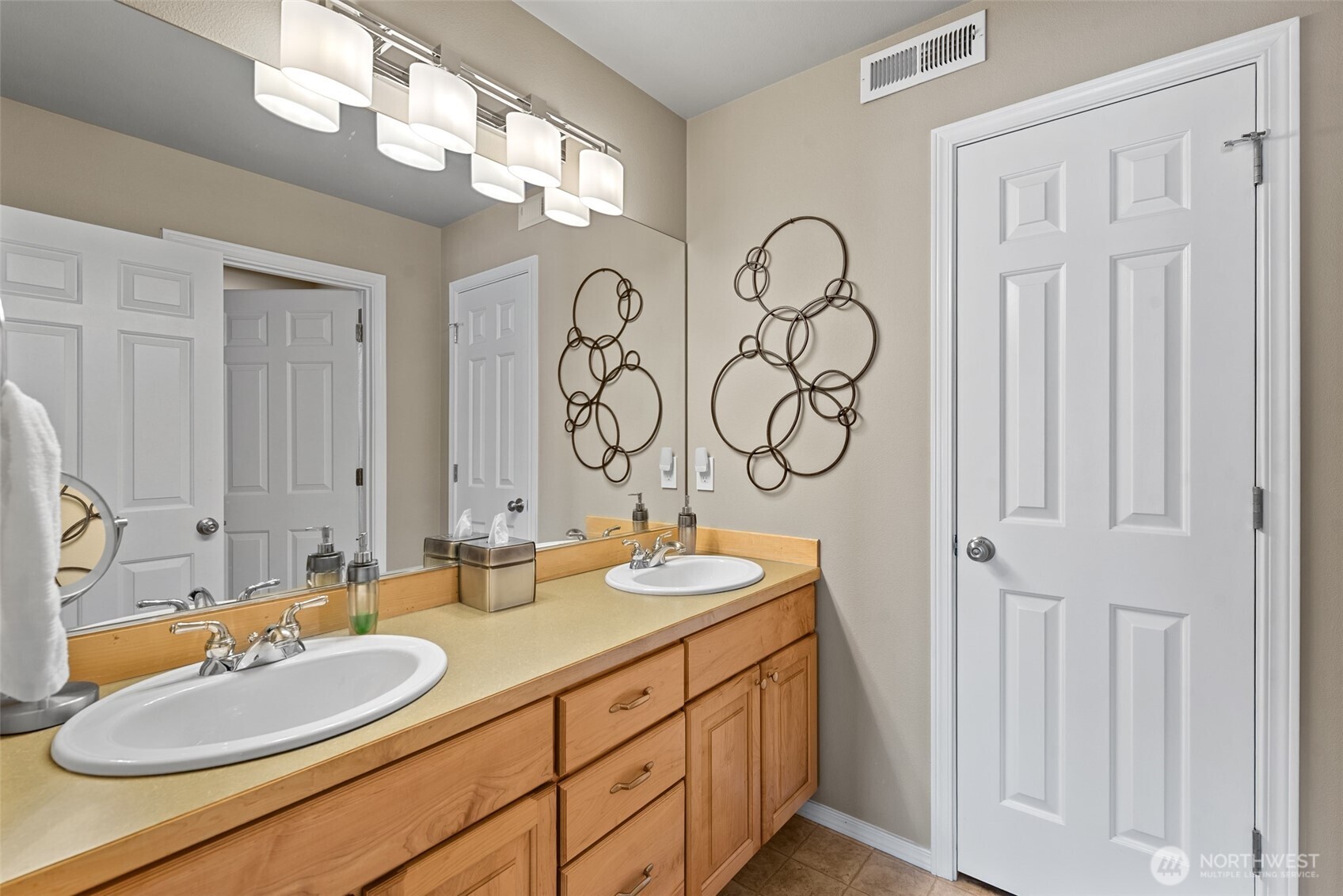 Lower-level full bathroom off the family room features dual sinks and a shower/tub.