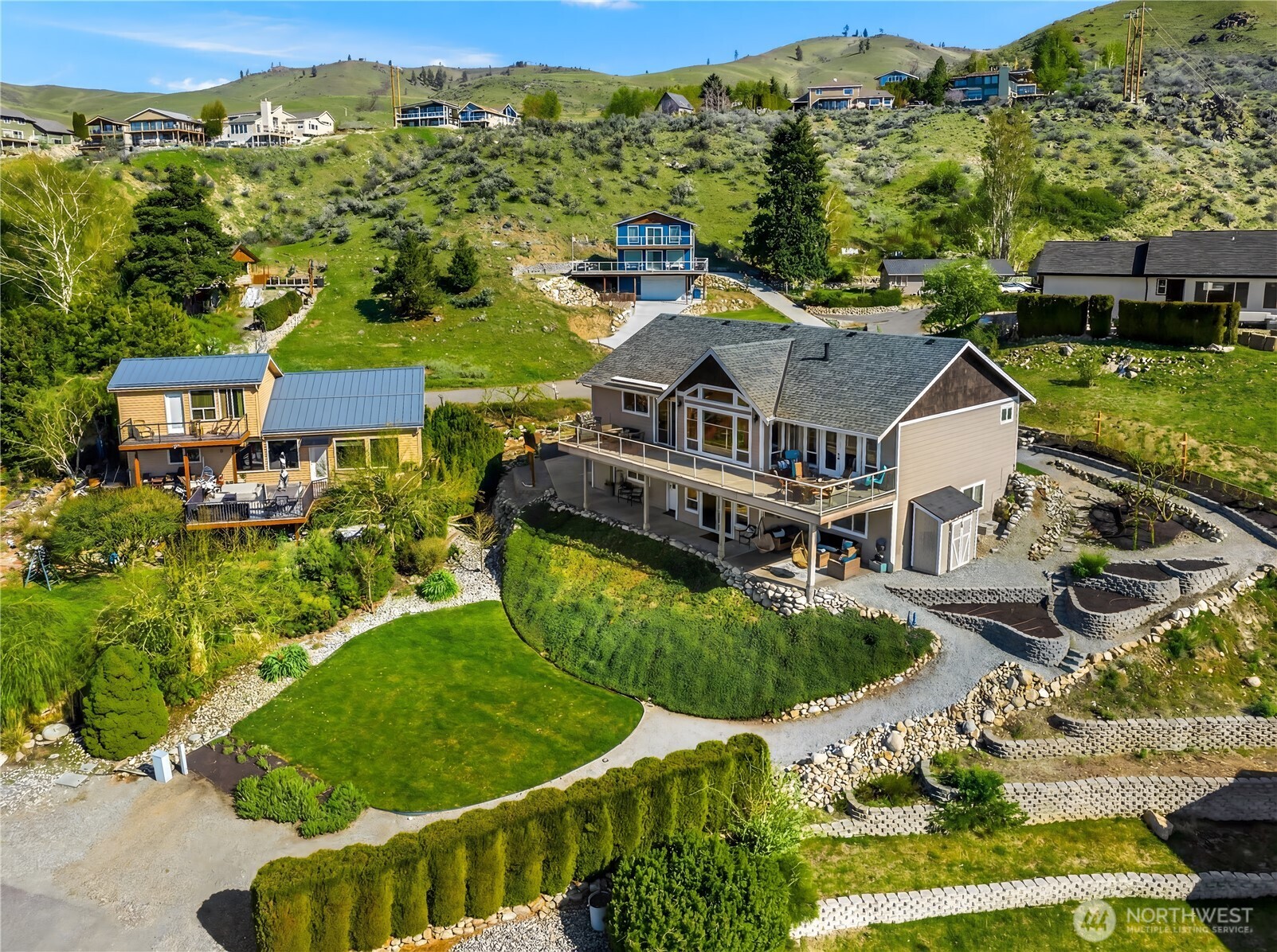 Terraced garden beds paired with a well-placed storage shed create the perfect setup for gardening, and driving access from Stehekin Way as well as from Wapato Court on the lower yard provide lots of flexibility.