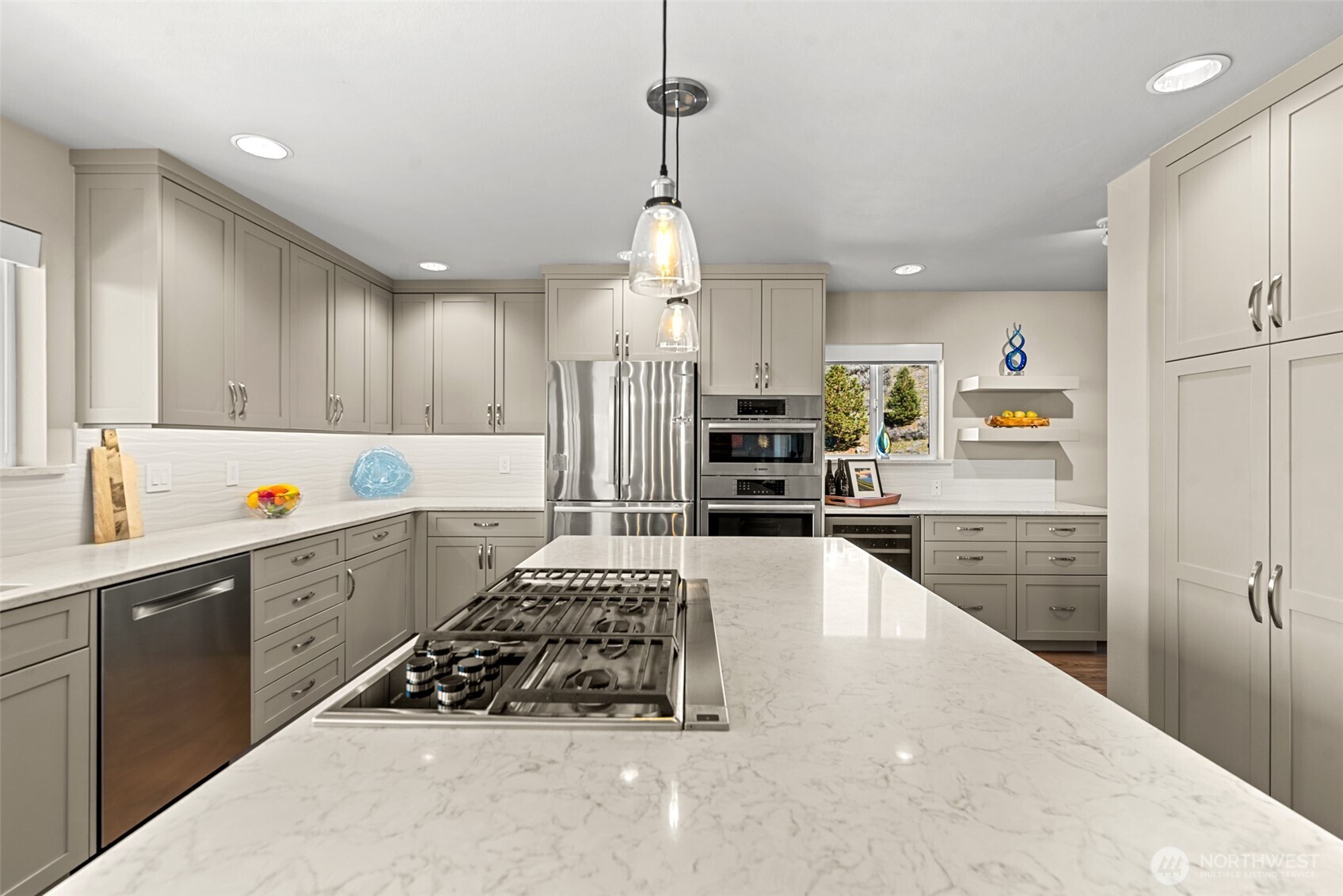 Bright kitchen with a 5 burner downvented propane cooktop, convection oven, quartz countertops and abundant storage for added organization and functionality.  An additional refrigerator/freezer and extra freezer are in the garage.