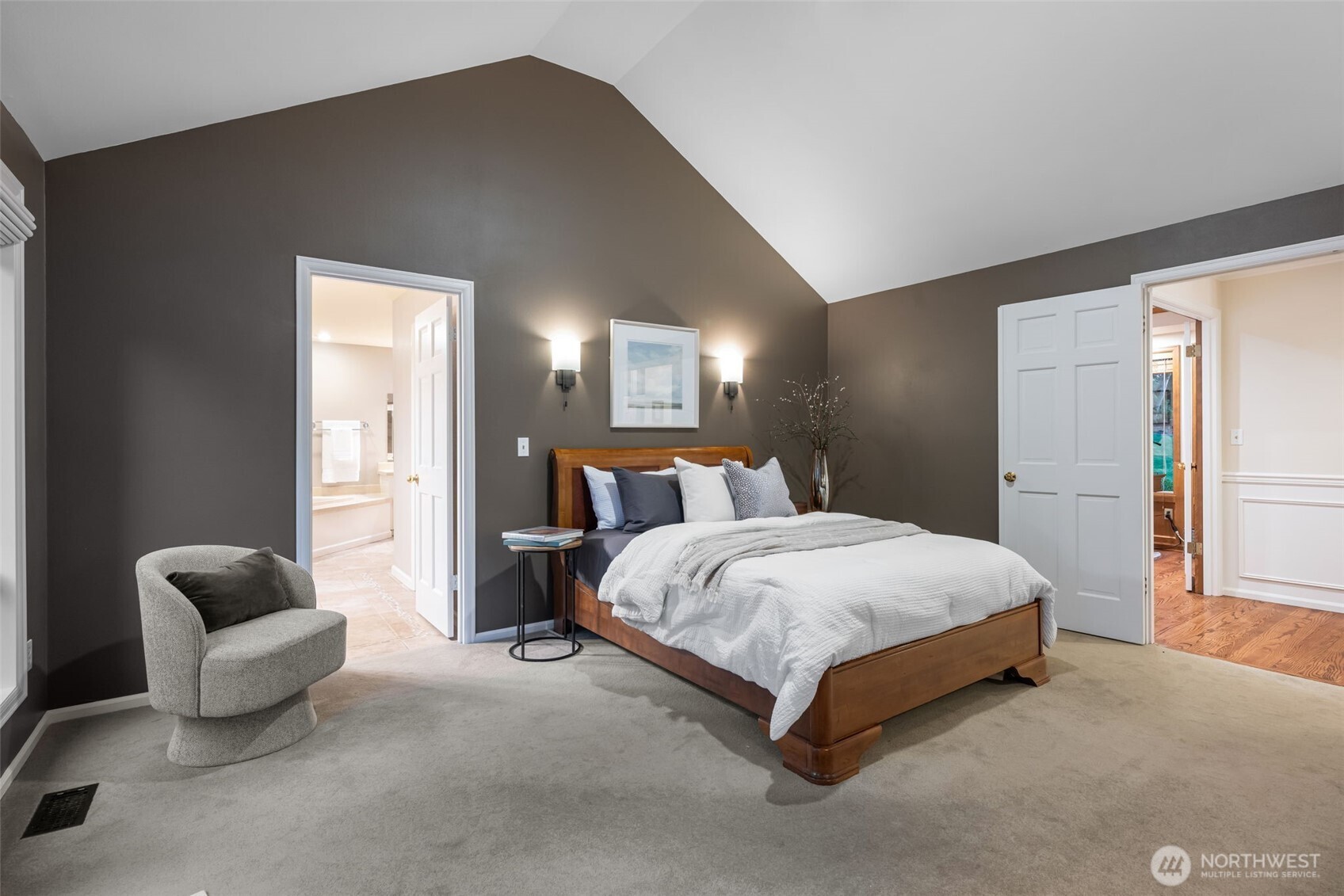 Generous primary bedroom with vaulted ceilings and French doors.