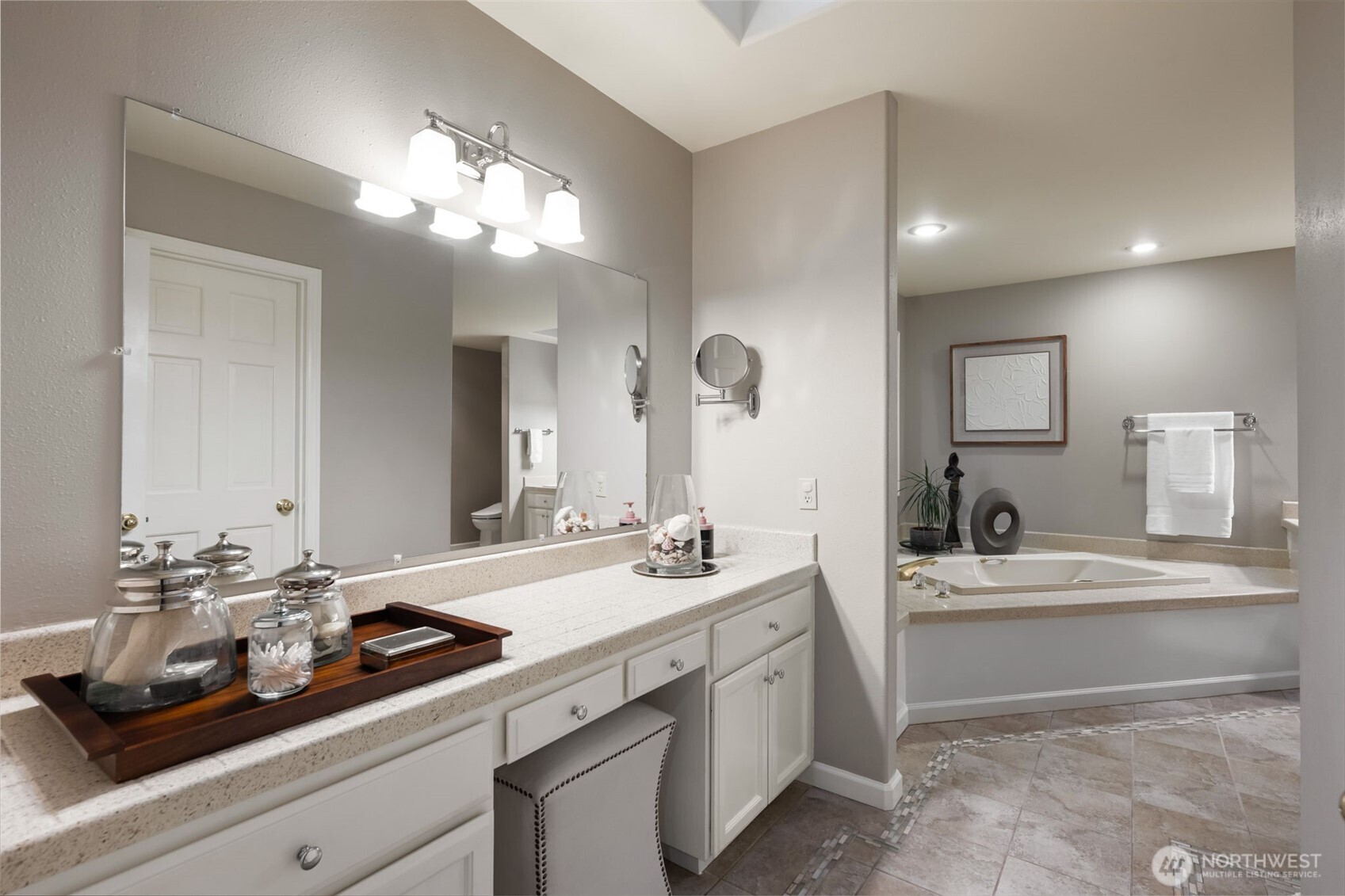 Large primary bathroom with dual vanities, soaking tub, & spacious walk-in closet.