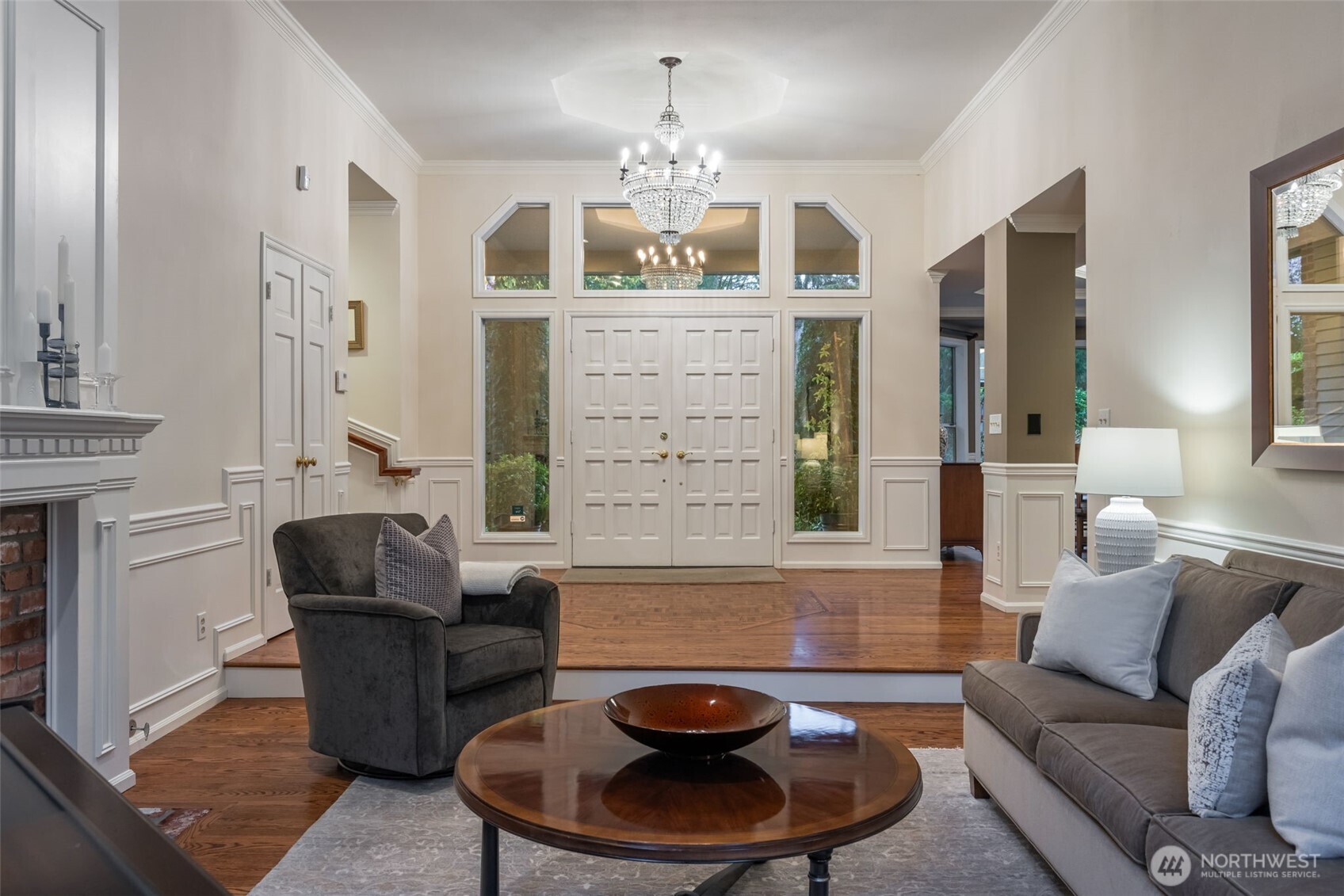 Sophisticated entry with tall ceilings and mirrored arching entry and window wall detailing.