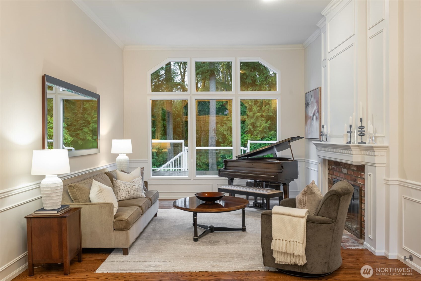 Sunken living room with dual burning wood & gas fireplace, overlooks the expansive backyard.