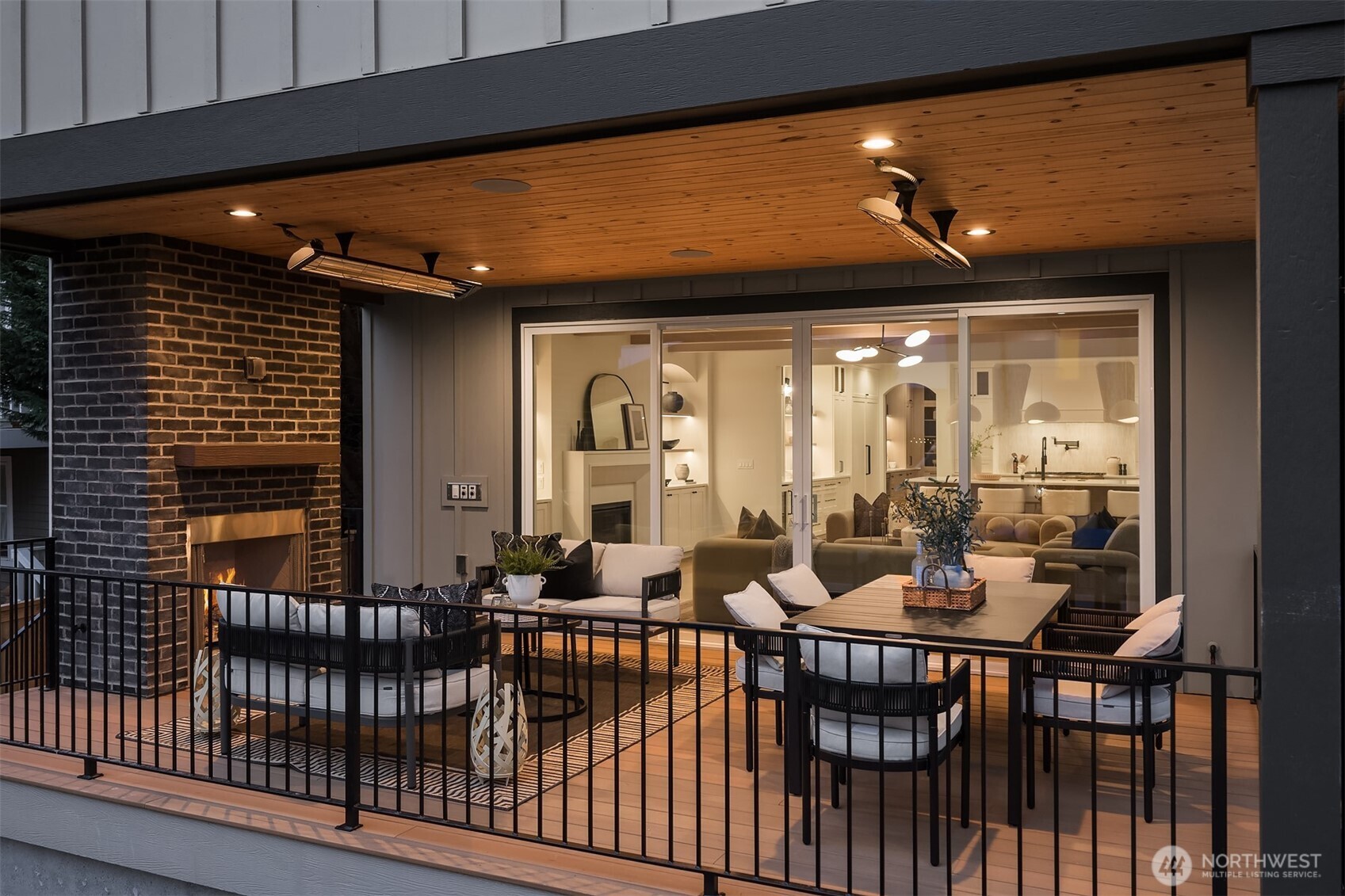 overed outdoor living area featuring a cozy fireplace, heated pannels for all year round living and entertaining, ample space for dining and lounging, and Sonos speakers.