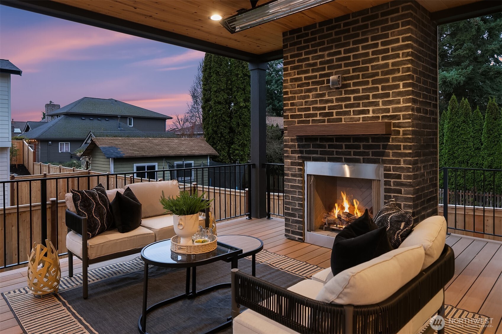 Covered outdoor living space centered around a stunning fireplace, offering a warm and inviting setting for relaxing or entertaining year-round.