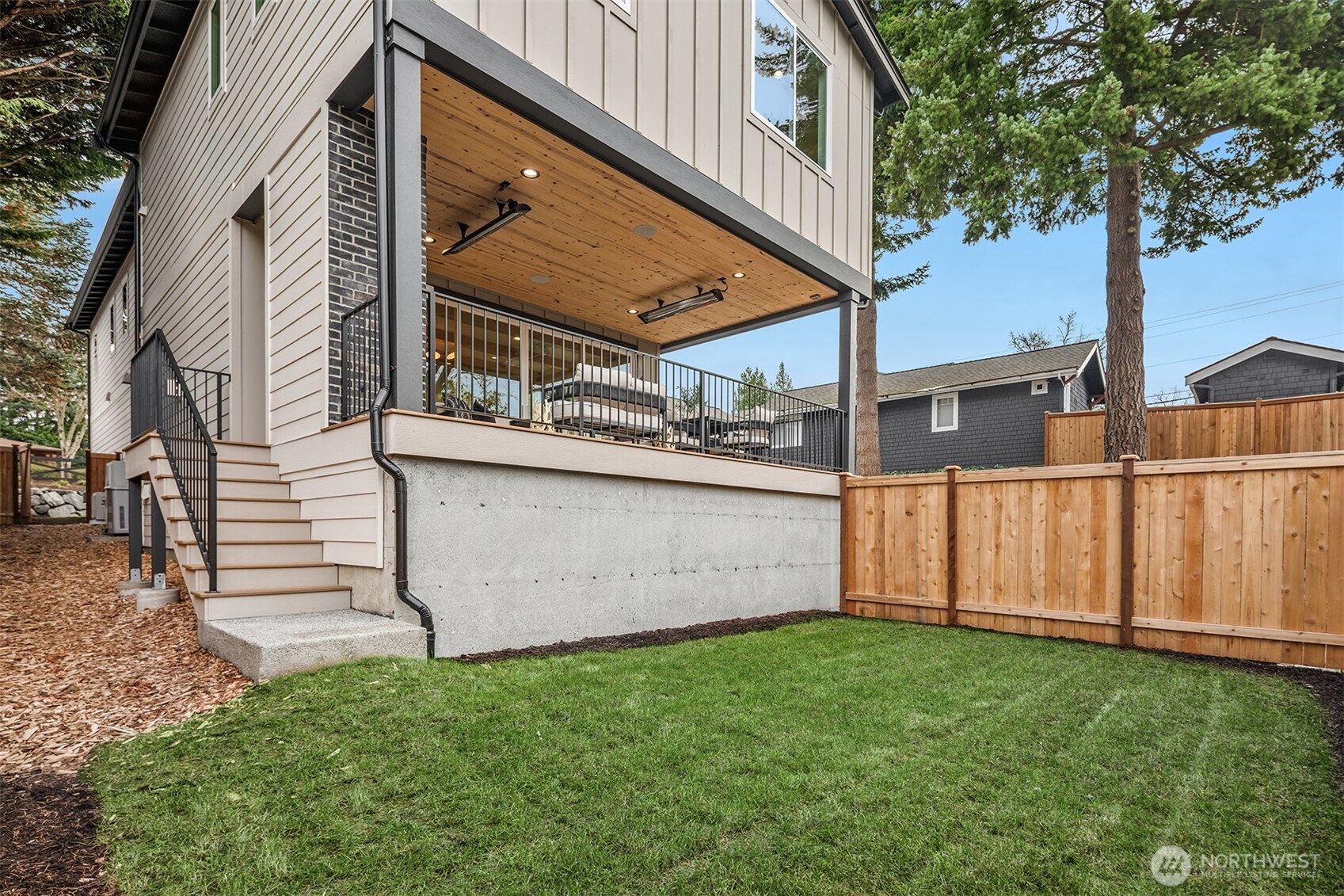 Fully fenced, landscaped yard features a smart Wi-Fi sprinkler system, BBQ gas stub, and a covered patio with outdoor fireplace, Sonos speakers and electric heaters for year-round enjoyment.
