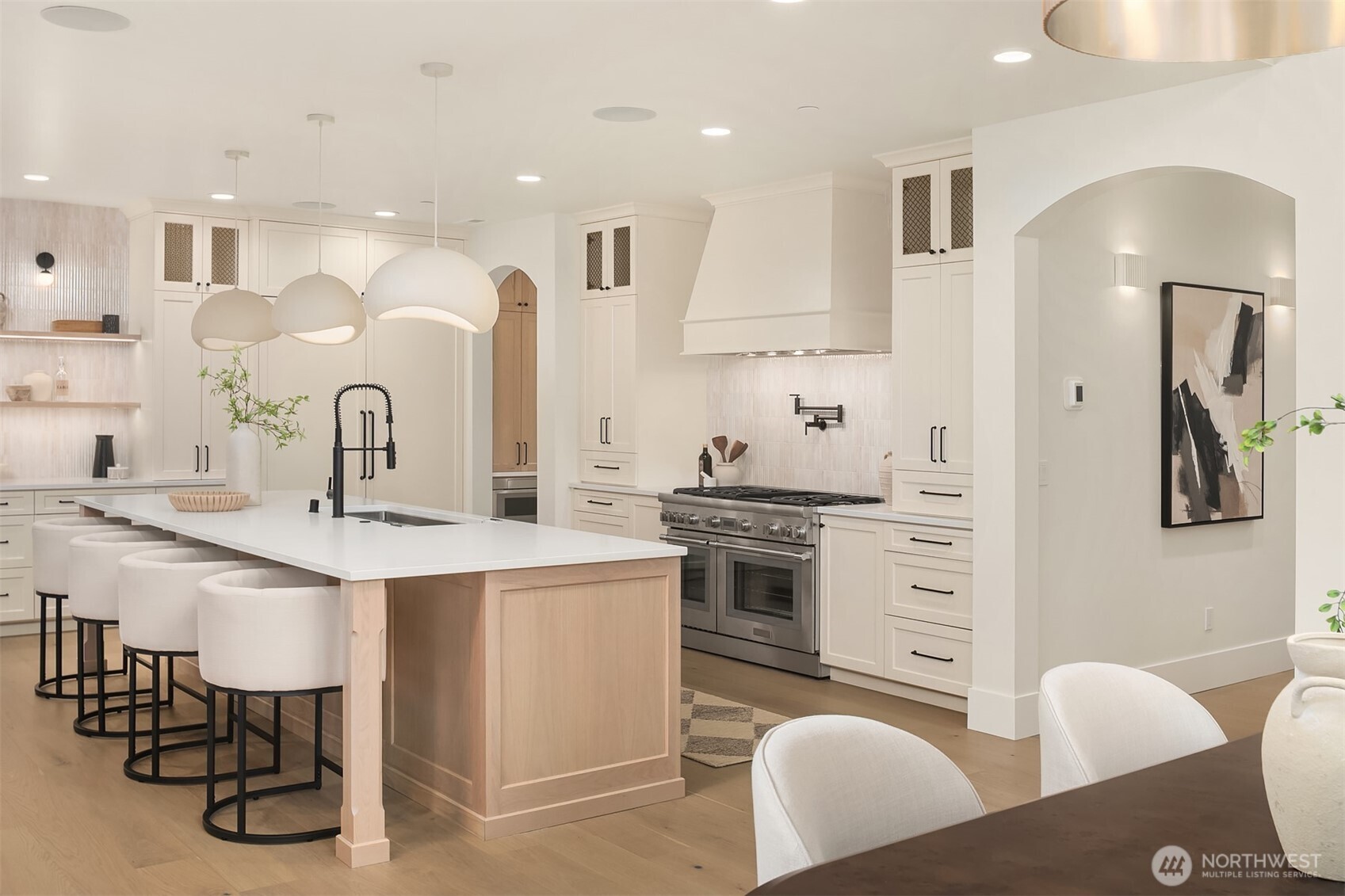 Chef’s kitchen with Thermador appliances, expansive island, custom cabinetry, and designer lighting, designed for both everyday living and entertaining.
