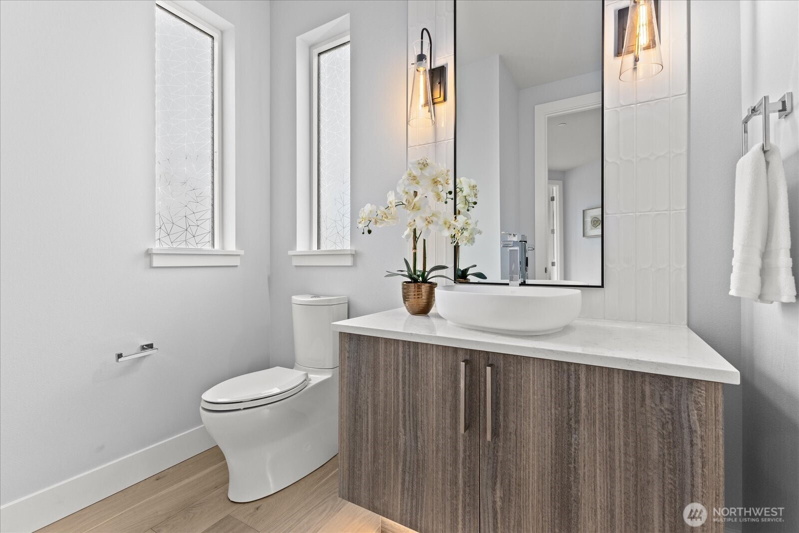 A beautifully styled powder bath with designer lighting, elevated finishes, and a modern vanity that turns a functional space into a design moment.