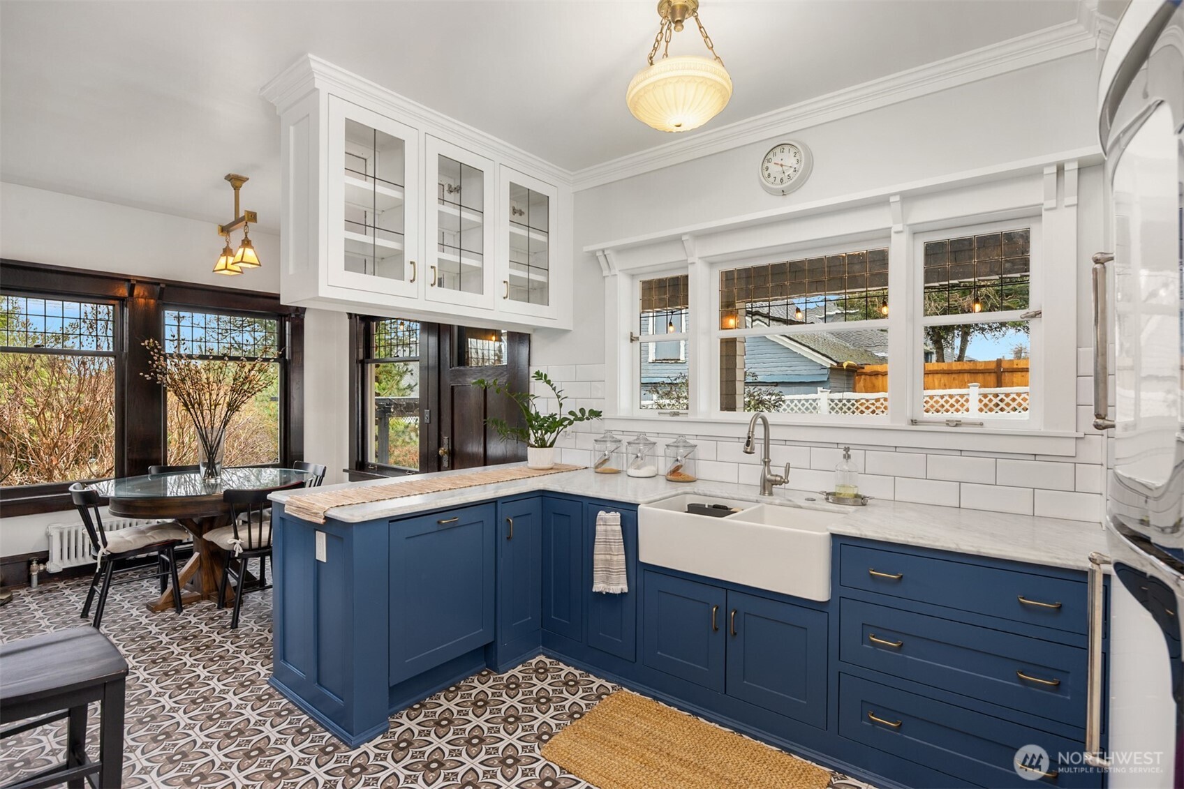 Timeless details shine in this chef-worthy kitchen, featuring a farmhouse sink, classic subway tile, marble counter tops, and a statement vintage-style refrigerator—where old-world character meets contemporary convenience.