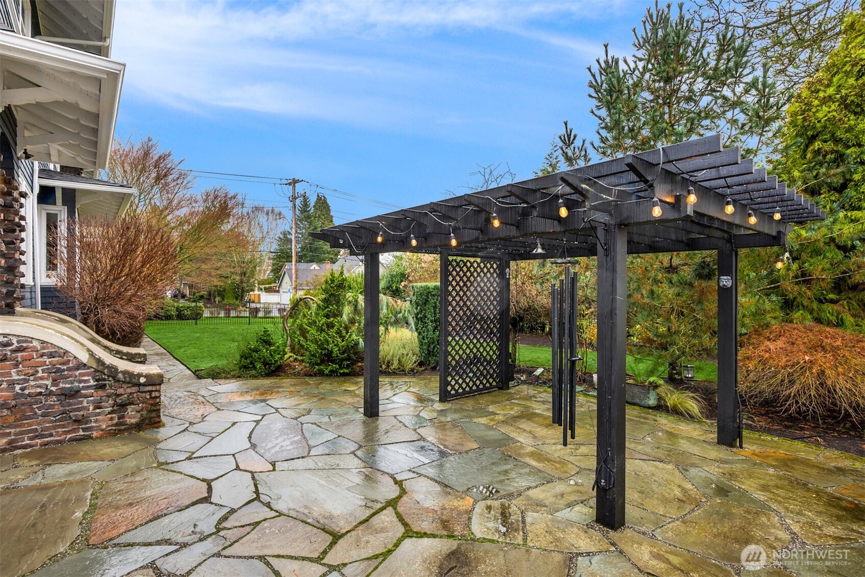 The backyard is unexpectedly expansive and beautifully curated, featuring a stone patio, pergola with ambient lighting, manicured lawn, and layered garden beds. Fully enclosed and thoughtfully designed, it offers privacy, versatility, and year-round enjoyment — equally suited for entertaining or quiet moments at home.