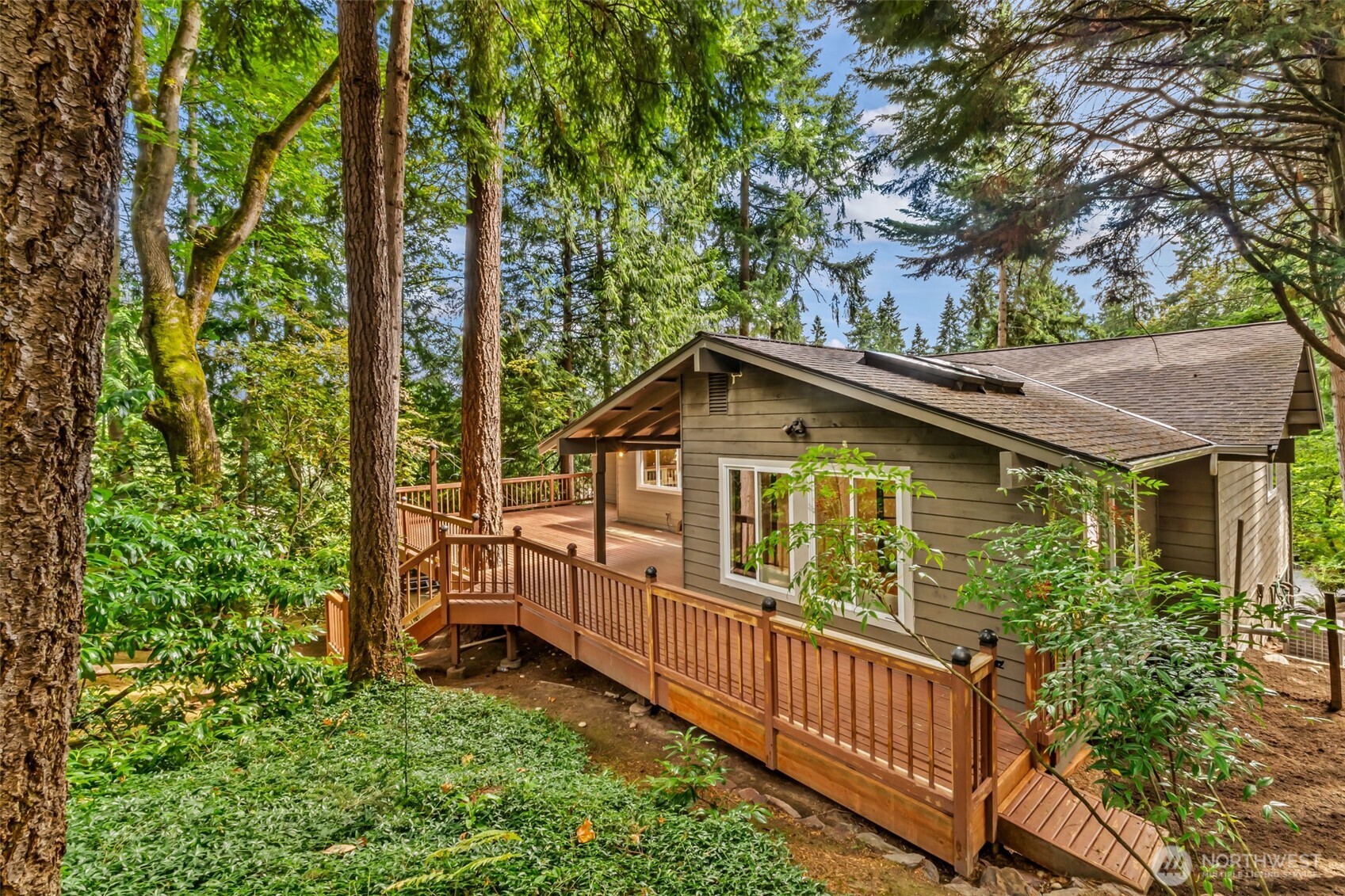 View of massive deck, extra private lot, and tons of greenery.