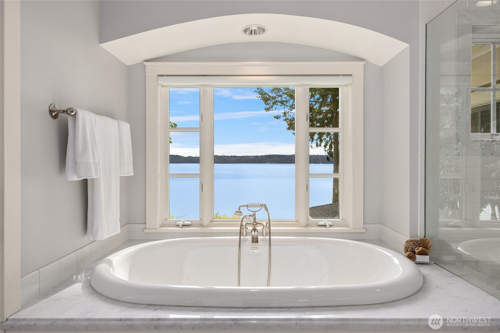 Besides a glass surrounded walk in shower, there is a soaking tub with a view.
