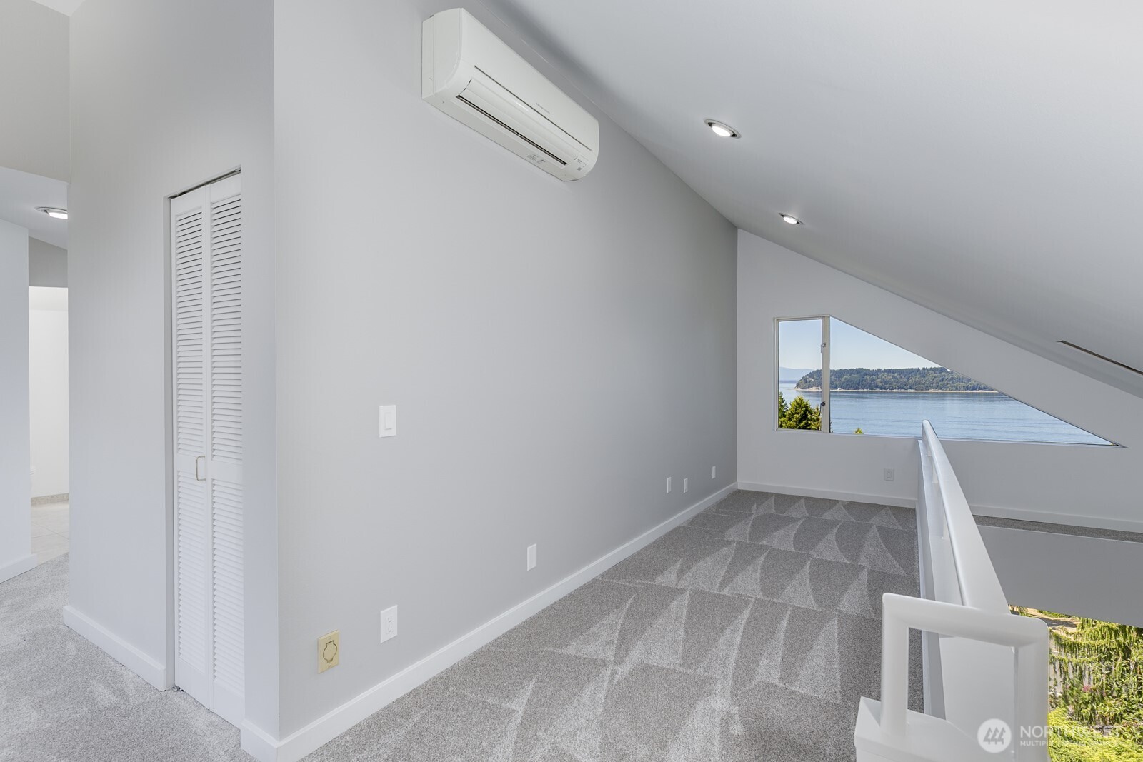Looking from the top of the stairs to the second level through theoffice space to the view. There is a mini-split here and in the primary bedroom that provide cooling when needed.