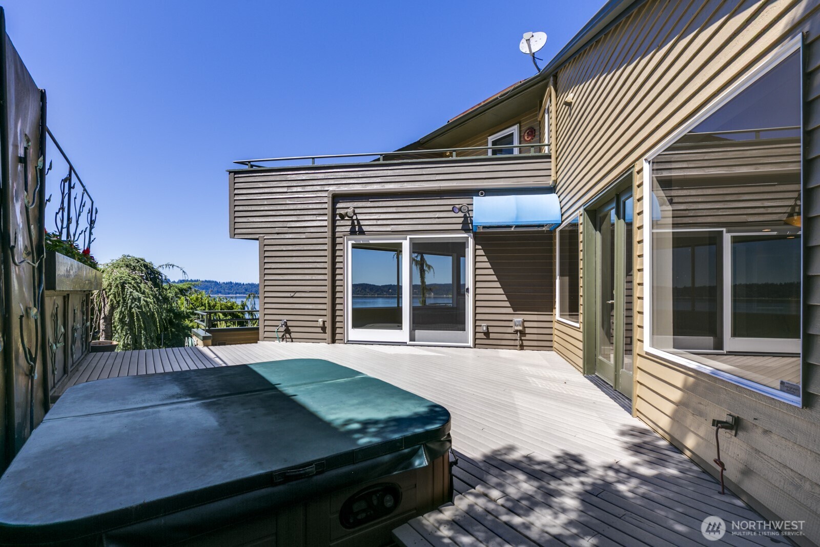 The side deck walks out from the family room on the right or the dining room ahead. The primary bedroom view deck is above. This deck is on the south side of the home for good sun exposure.