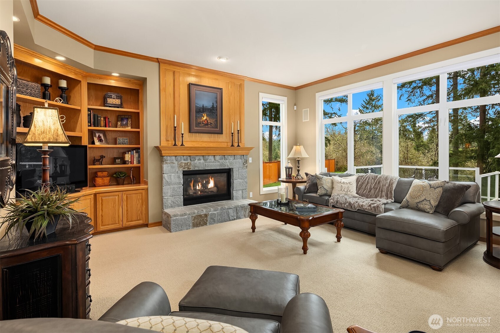Family room with stone fireplace and built-in shelving. Private, wooded outlooks from nearly every room in the home.
