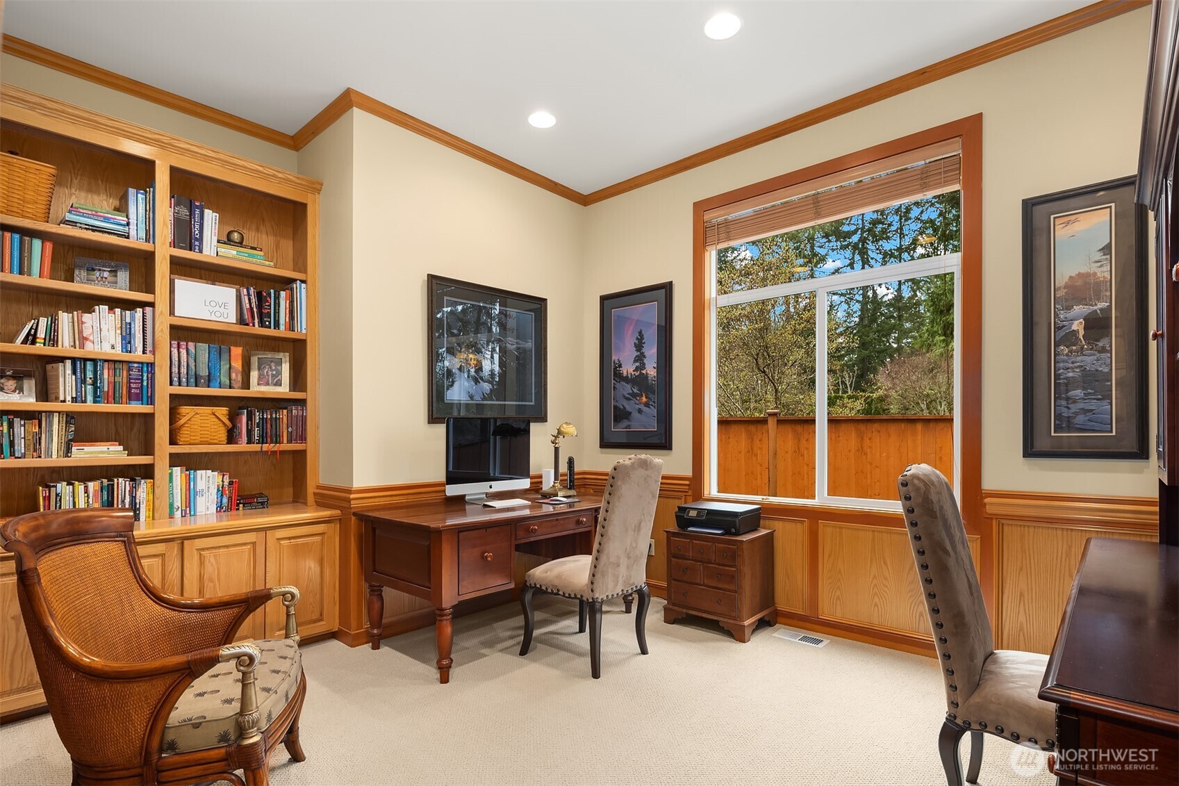 The large main level den/office allows the space for two desk areas, with built-in cabinets, shelving, and shows the signature trim details including chair rail and crown molding.