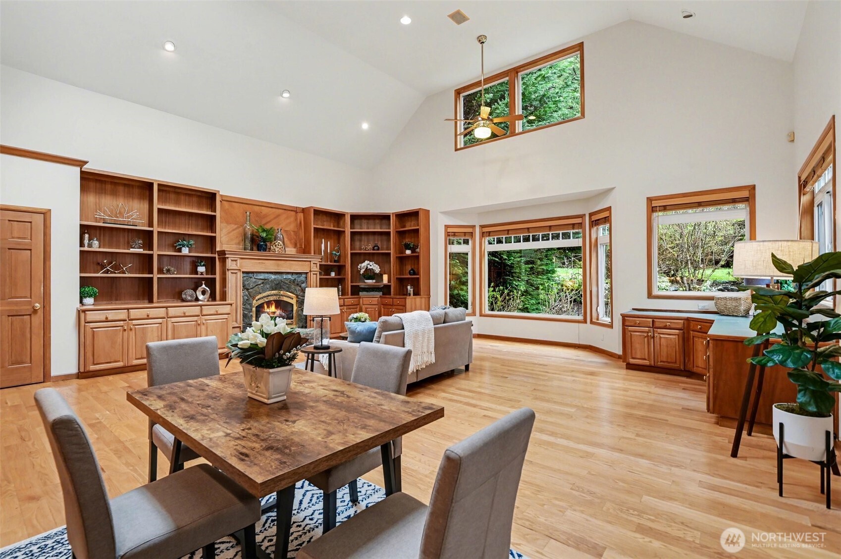 Soaring ceilings and expansive windows fill the home with natural light, creating an atmosphere that is both warm and refined in this great-room.