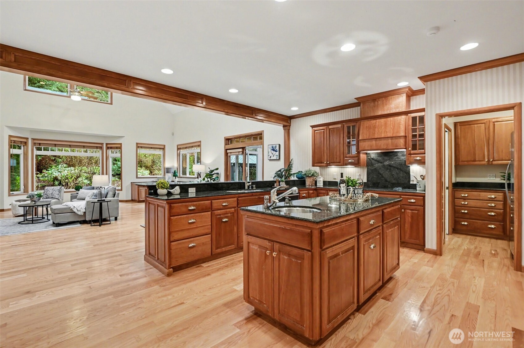 Soaring ceilings and expansive windows fill the home with natural light, creating an atmosphere that is both warm and refined in this great room.