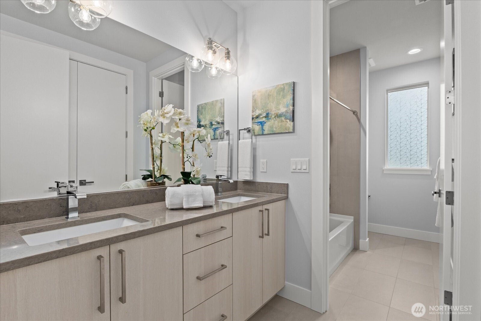 A bright and beautifully finished secondary bath with dual sinks, modern cabinetry, and clean, timeless style.