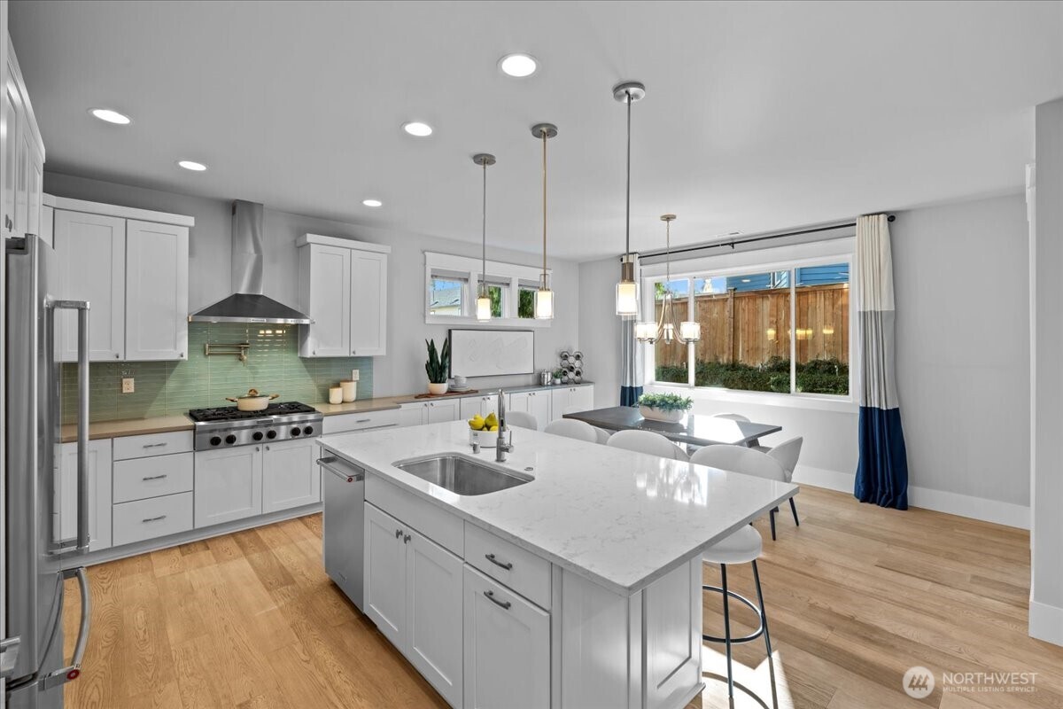 Step into this gorgeous kitchen with a large island, quartz counters, full height cabinets and pendant lighting. The gas range with pot filler make cooking a joy!