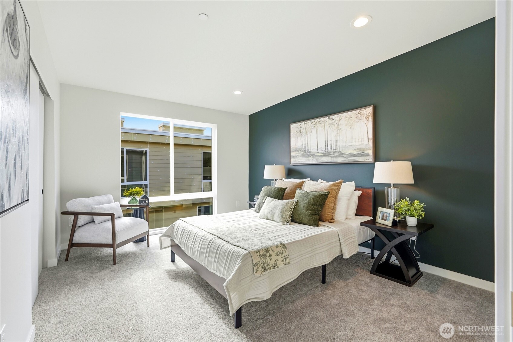 The upper level Primary bedroom has a floor-to-ceiling window that floods the room with light, as well as a walk-in closet and access to the shared bath.