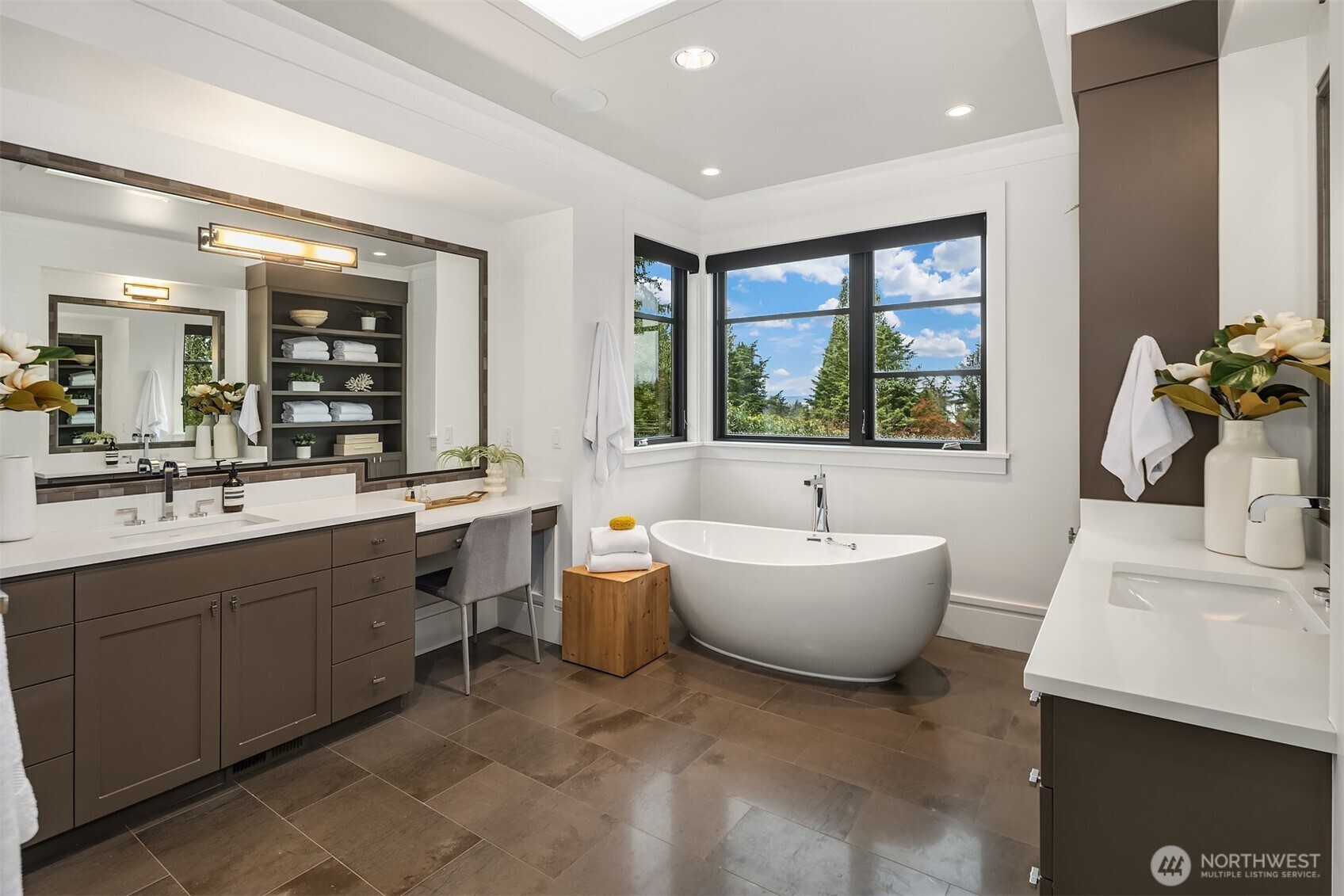 En-suite bath with freestanding soaking tub, dual vanities, custom built-ins, and toasty heated floors.