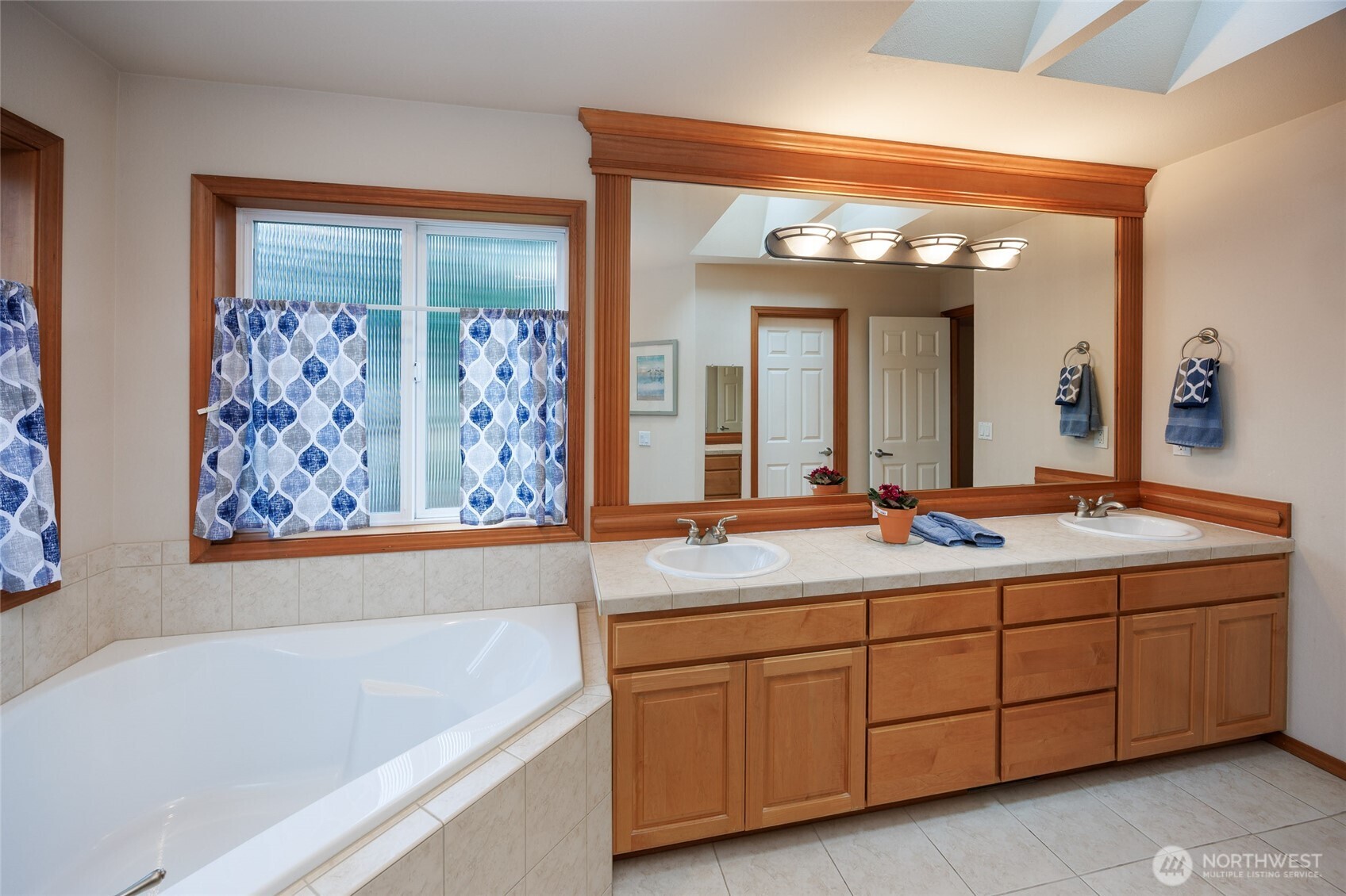 Primary bathroom w/tiled floors/countertops. Dual vanities/corner soaking tub /walk in shower and large walk in closet.