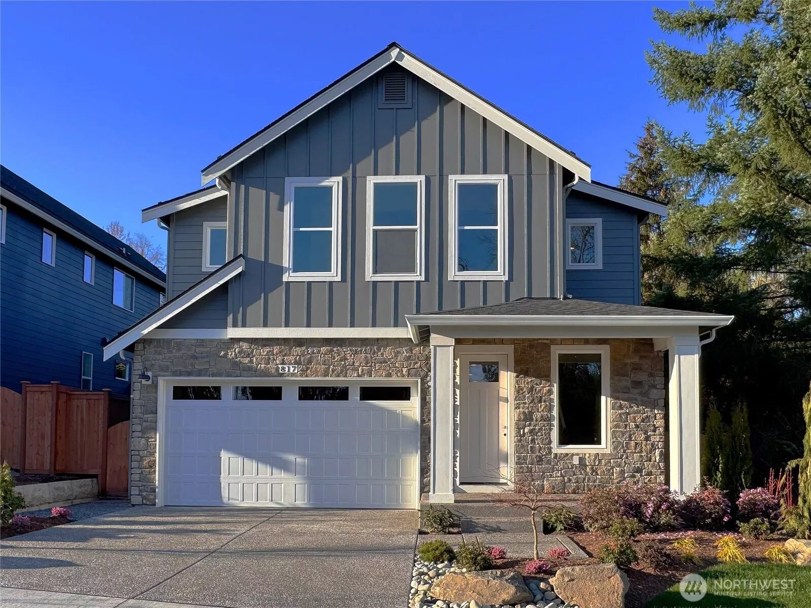 Exterior | Homesite 1  The Robinson plan on the south-facing homesite 1 showcases clean Pacific Northwest contemporary lines with a balanced mix of vertical siding and stone accents. Large upper-level windows introduce natural light while the covered entry creates a defined and welcoming approach. The streamlined façade reflects the architectural character associated with modern luxury new construction.    Located in Bothell’s Canyon Park neighborhood, this thoughtfully designed home is currently under construction. Garage and front door colors are subject to change as finishes are finalized. The residence reflects the quality and craftsmanship expected in new construction homes served by the Northshore School District.    All photos, renderings, site maps, and floorplans are for visualization purposes only.